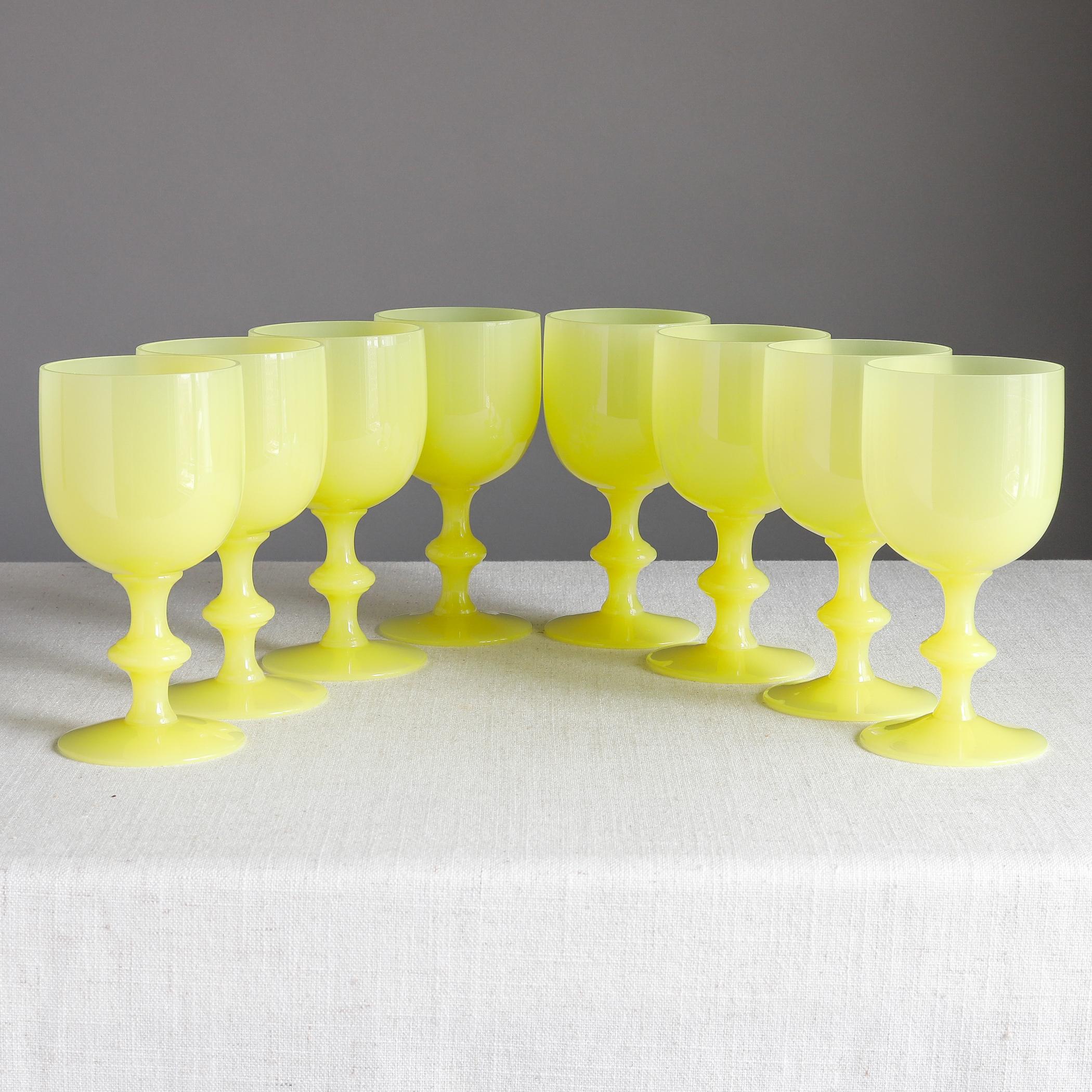 Set of eight yellow opaline glass goblets for water or wine by Portieux Vallerysthal of France, each with a knopped stem. 

Each measures about 6 1/2 inches high, 3 3/8 inches diameter across the mouth, mid-20th century.

Overall condition is