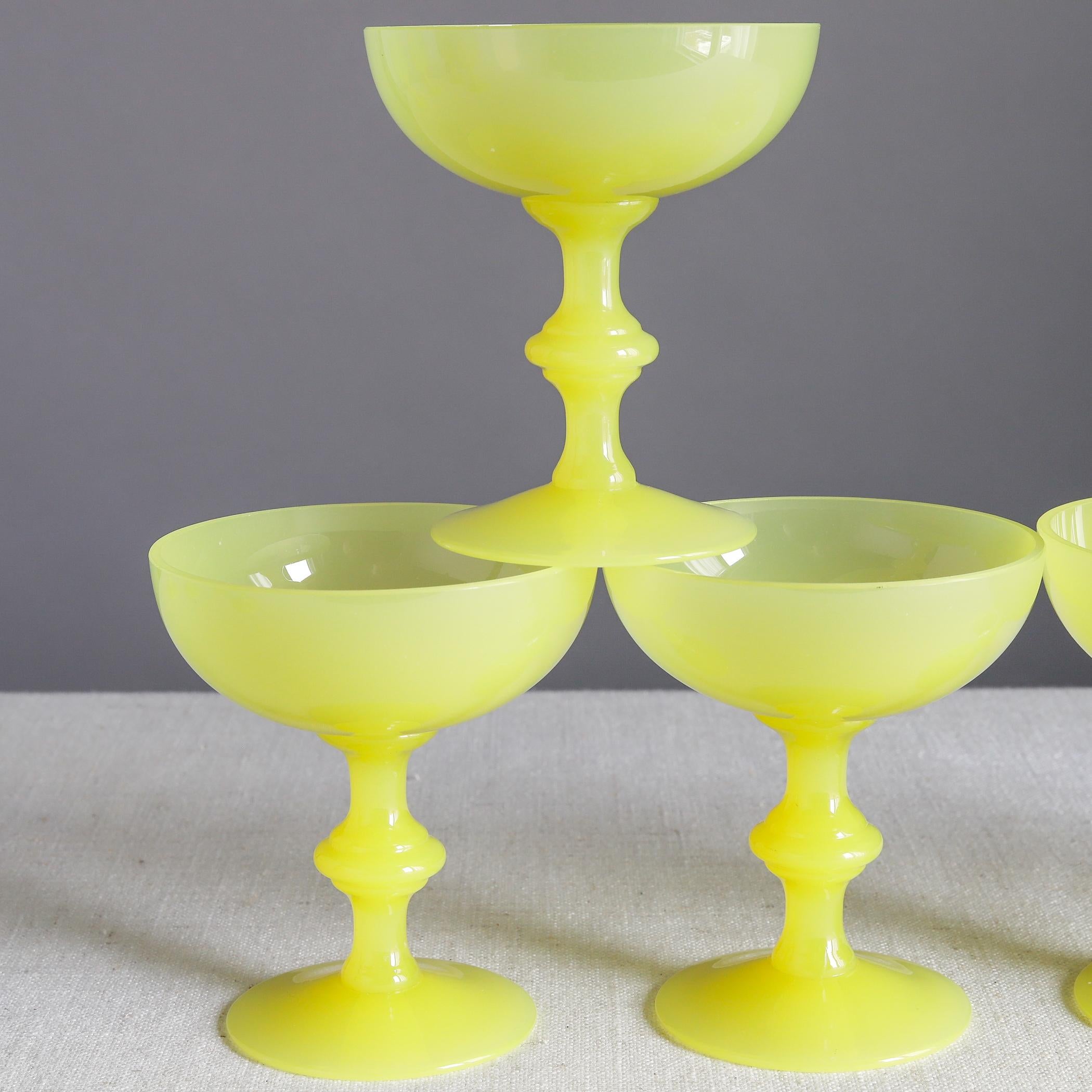 Set of five yellow opaline glass champagne coupes or sherbet glasses Portieux Vallerysthal of France, each with a knopped stem. 

Each measures about 4 1/4 inches high, 3 3/4 inches diameter across the mouth, mid-20th century.

Overall condition
