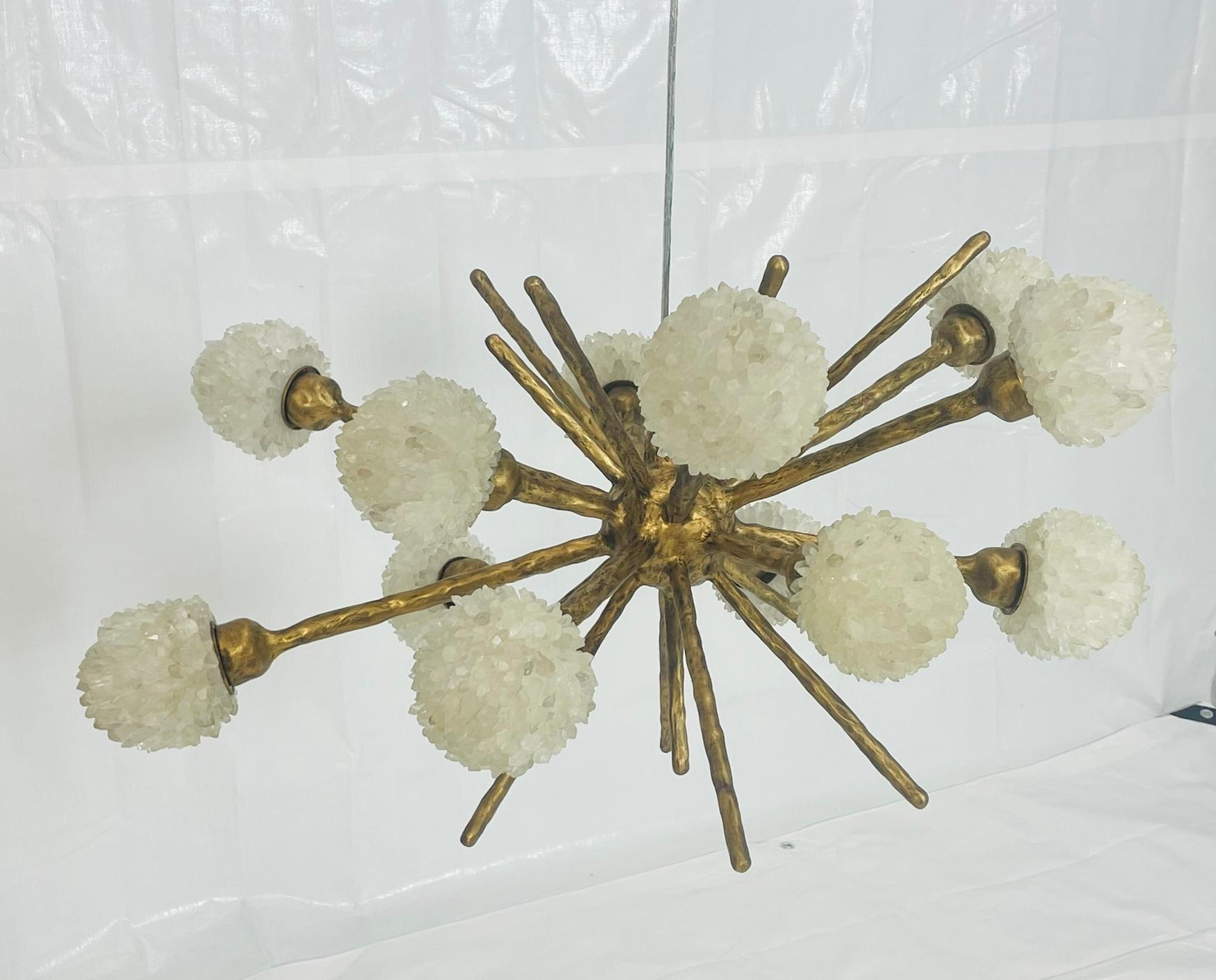 Parte dell'acclamata Porto Alegre Collection di Haus of Aurah, questo lampadario scultoreo fonde la bellezza minerale naturale con l'arte contemporanea. Fuso in bronzo con finitura oro anticato, il pezzo presenta bracci radianti coronati da grappoli
