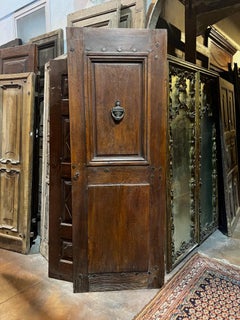 Puerta antigua de nogal, una hoja con panel y badajo