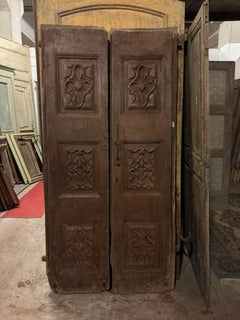 Double front door with rich carved panels, italy