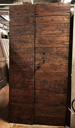 Asymmetrical double-leaf nail-studded door made of poplar wood. 19th century
