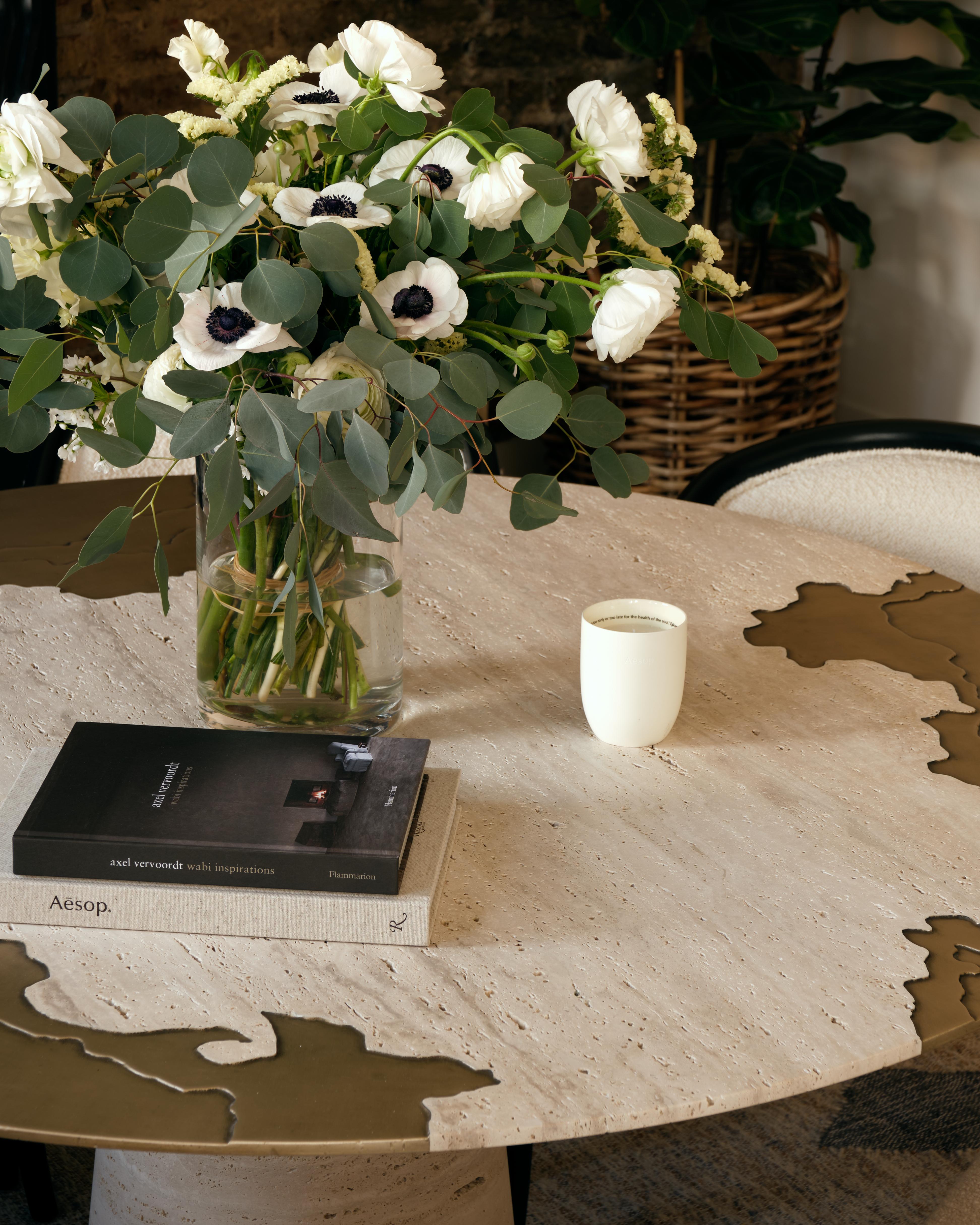 The Portonovo dining table is the very first piece created for Studio Sam London Collection.
Made of the whitest travertine, the top surface is engraved and a liquid metal application is poured onto the engraved detailing to the perimeter and the