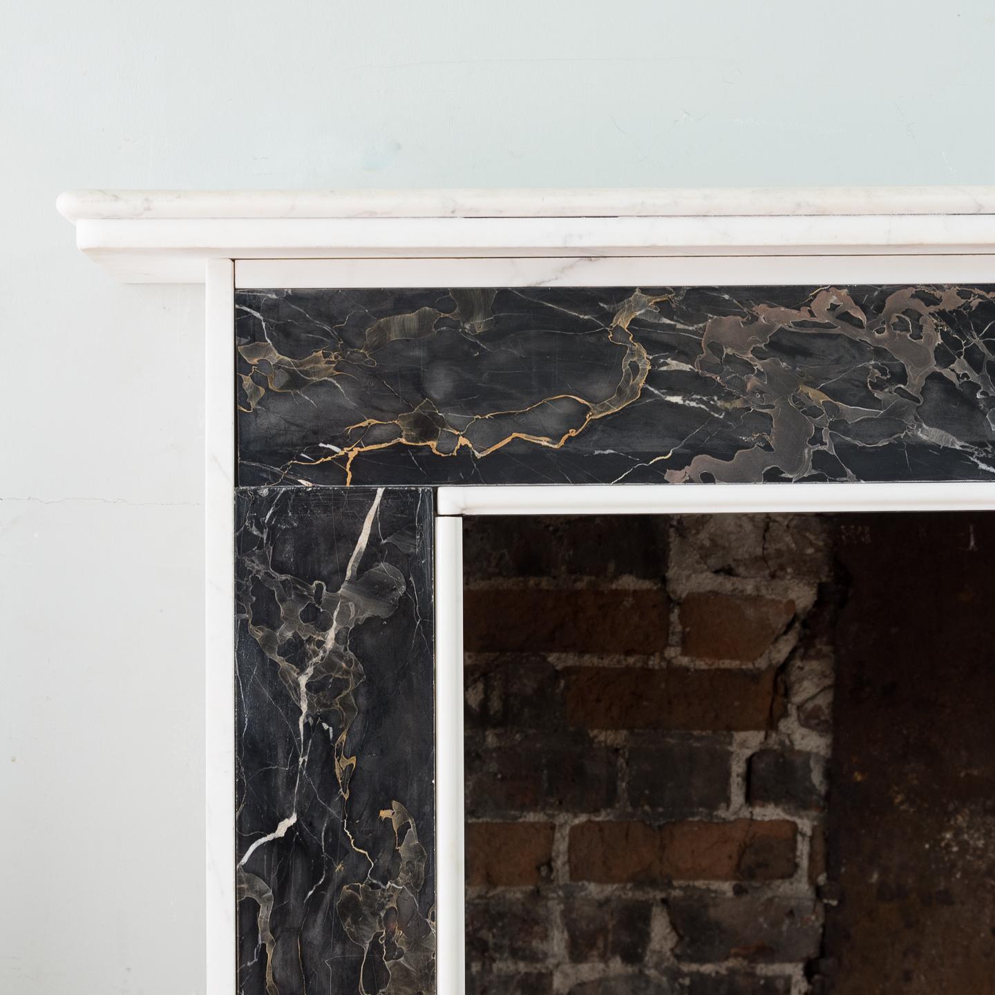 A Portoro and Carrara marble chimneypiece, removed from Pall Mall, London, the moulded shelf above jambs and frieze with inset Portoro panels, with moulded in grounds, on block feet, circa 1980 with earlier elements.
         