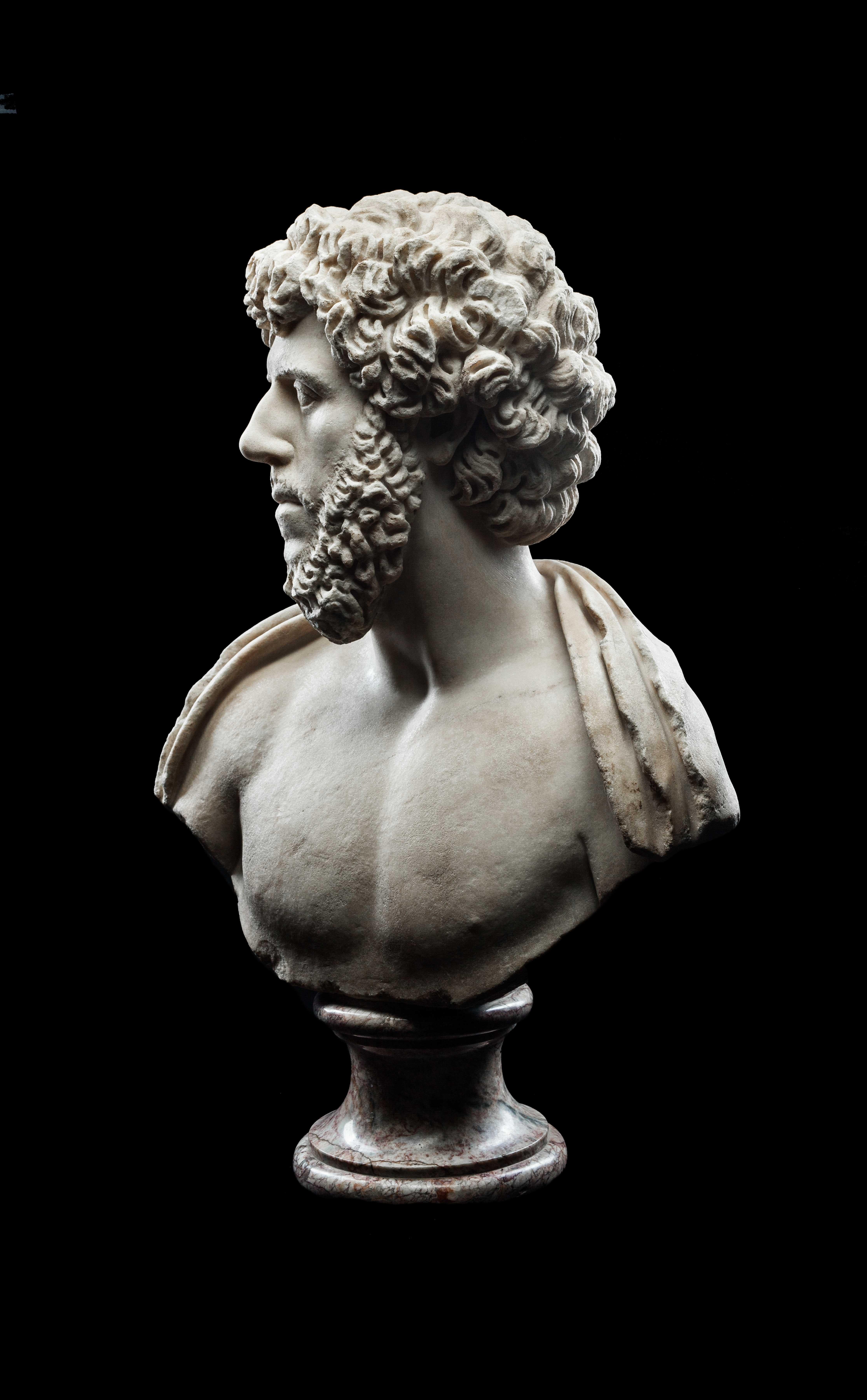This impressive bust is depicted with head turned slightly to the right and gaze lifted. His eyes are articulated, with the pupils indicated with a drill, giving the face a striking realism. The shoulders are draped with a cloak. Straight brows sit