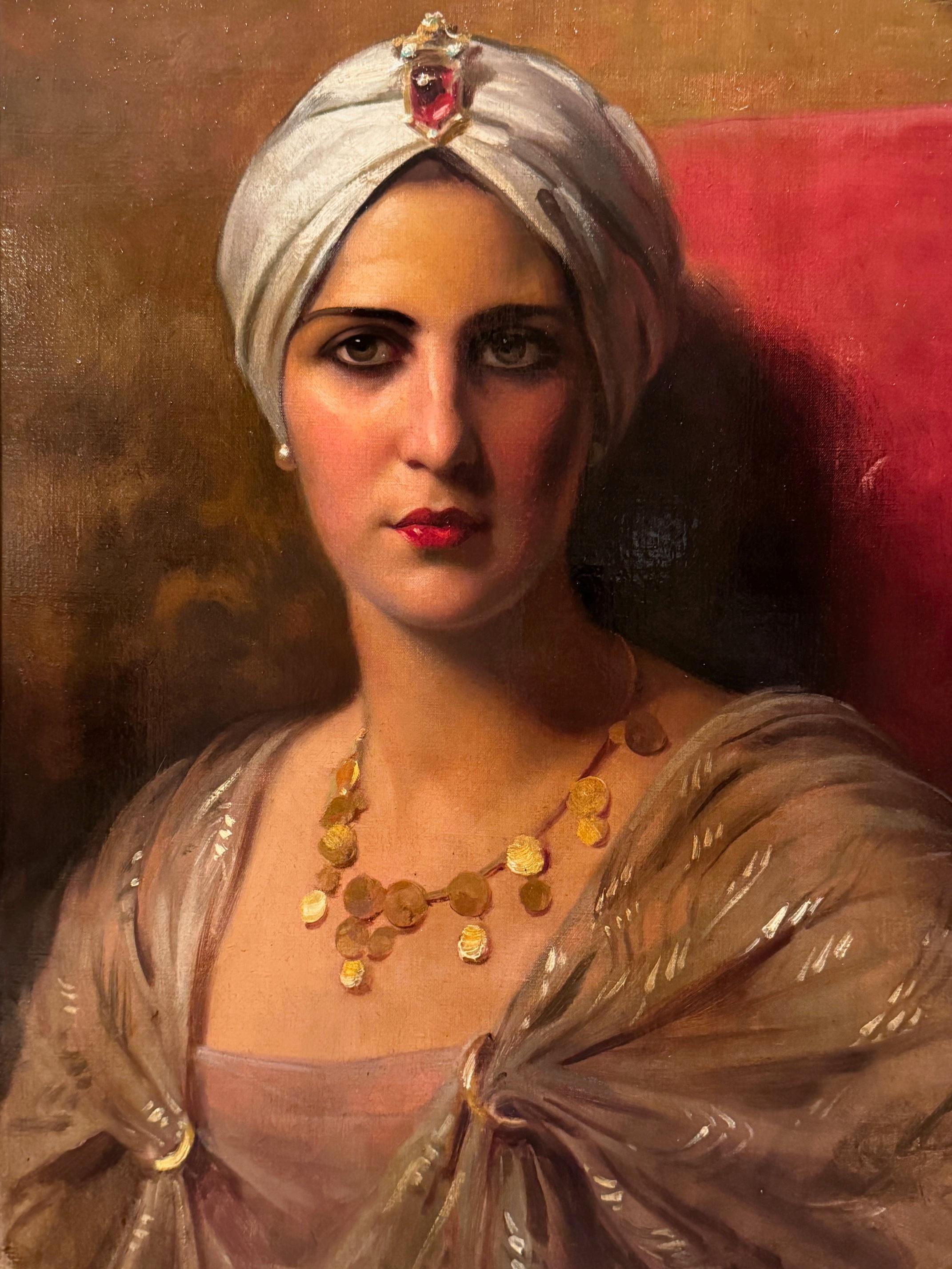 Oil on canvas depicting a beautiful young woman dressed in oriental style, wearing a necklace with gold coins and a turban topped with a large garnet or ruby cabochon broche. Her shoulders are covered with a shawl embroidered with golden motifs.
Her