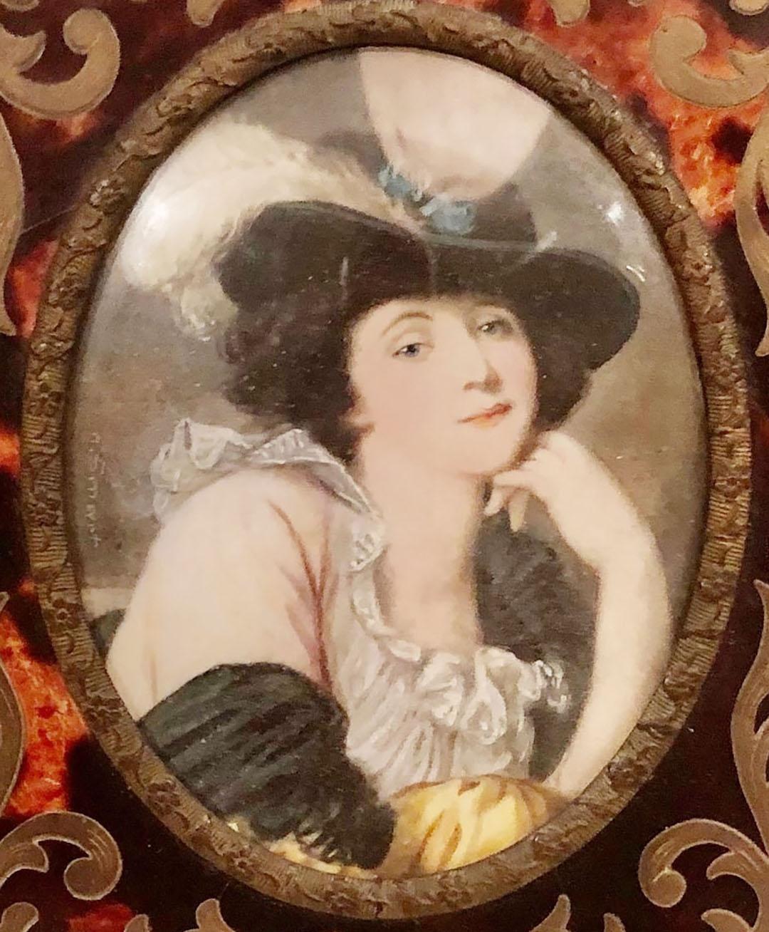 Portrait on ivory of a lady in a hat in a brass and tortoise shell frame. French paper on back. Circa 1880s, France.