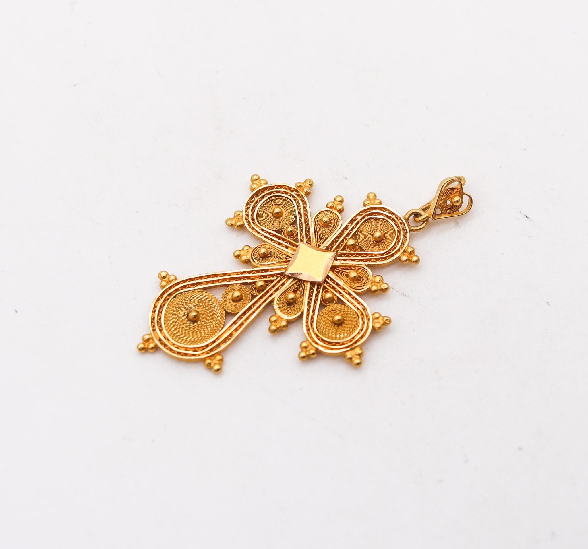 Portuguese filigree pendant cross.

Beautiful pendant cross, created in Portugal, during the Victorian era, back in the 1850 or earlier. Crafted in the shape of a Byzantine cross, with the filigree technique in solid yellow gold of 18 and 21 karats