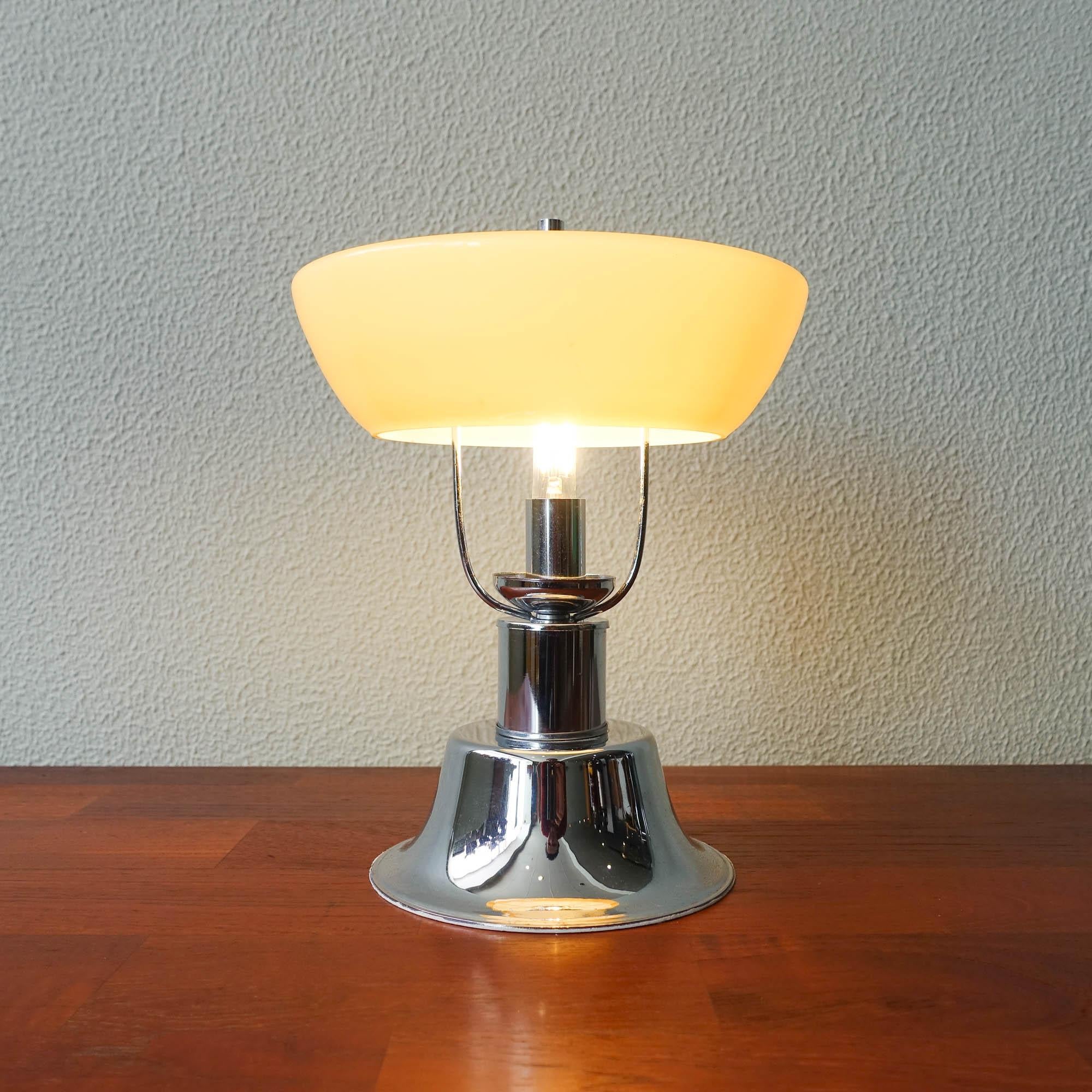 This table lamp was designed and produced in Portugal, during the 1940's.The base is made of chrome metal in a tulip shape where an yellow opaline mushroom shaped glass shade is set. It is in the original and good condition.