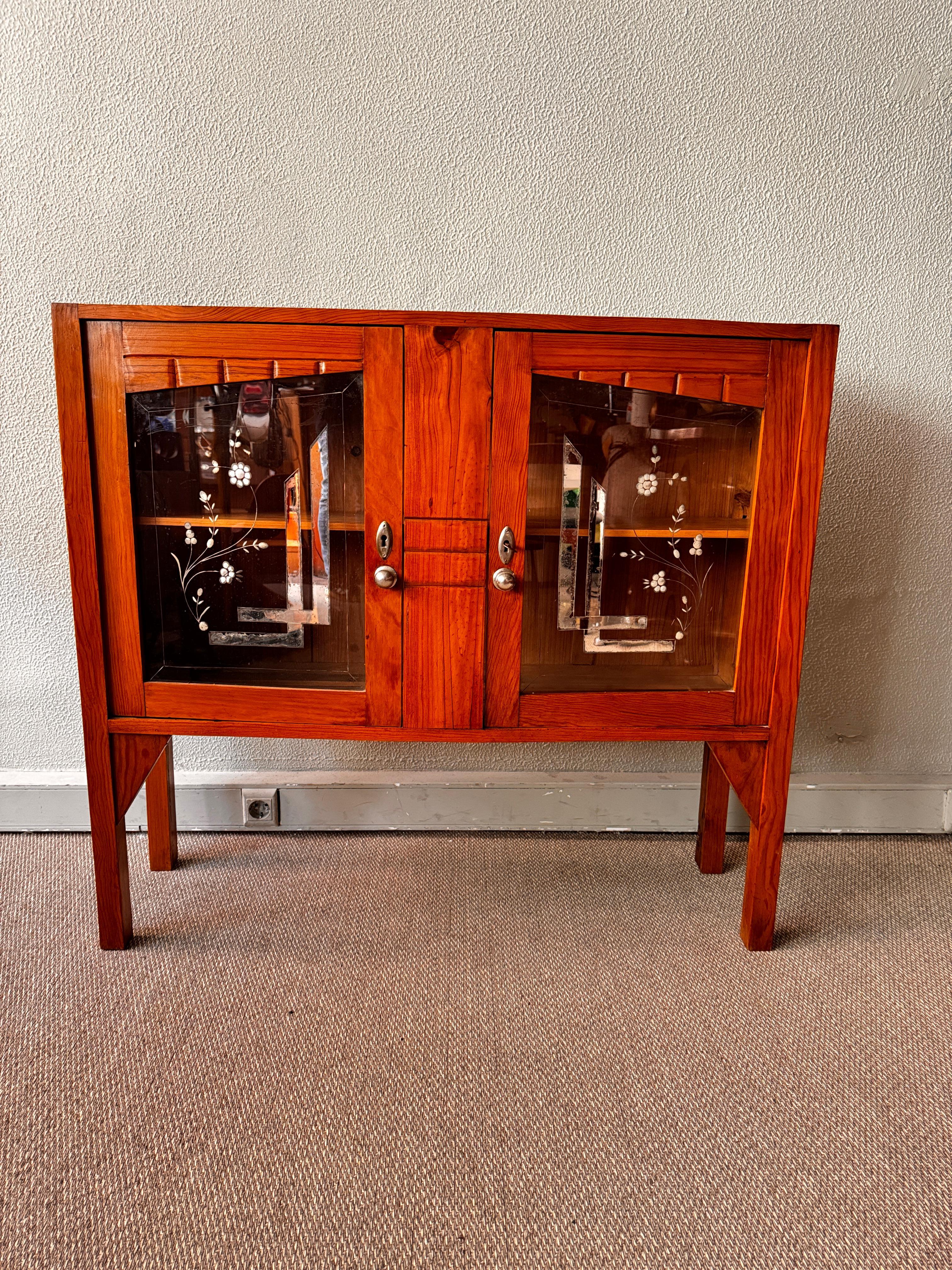 A rare example of Portuguese Art Nouveau furniture, this compact sideboard from the 1930s offers a striking balance of form and ornament. Crafted in richly toned bark wood, its silhouette fuses clean lines with subtle decorative flourishes,
