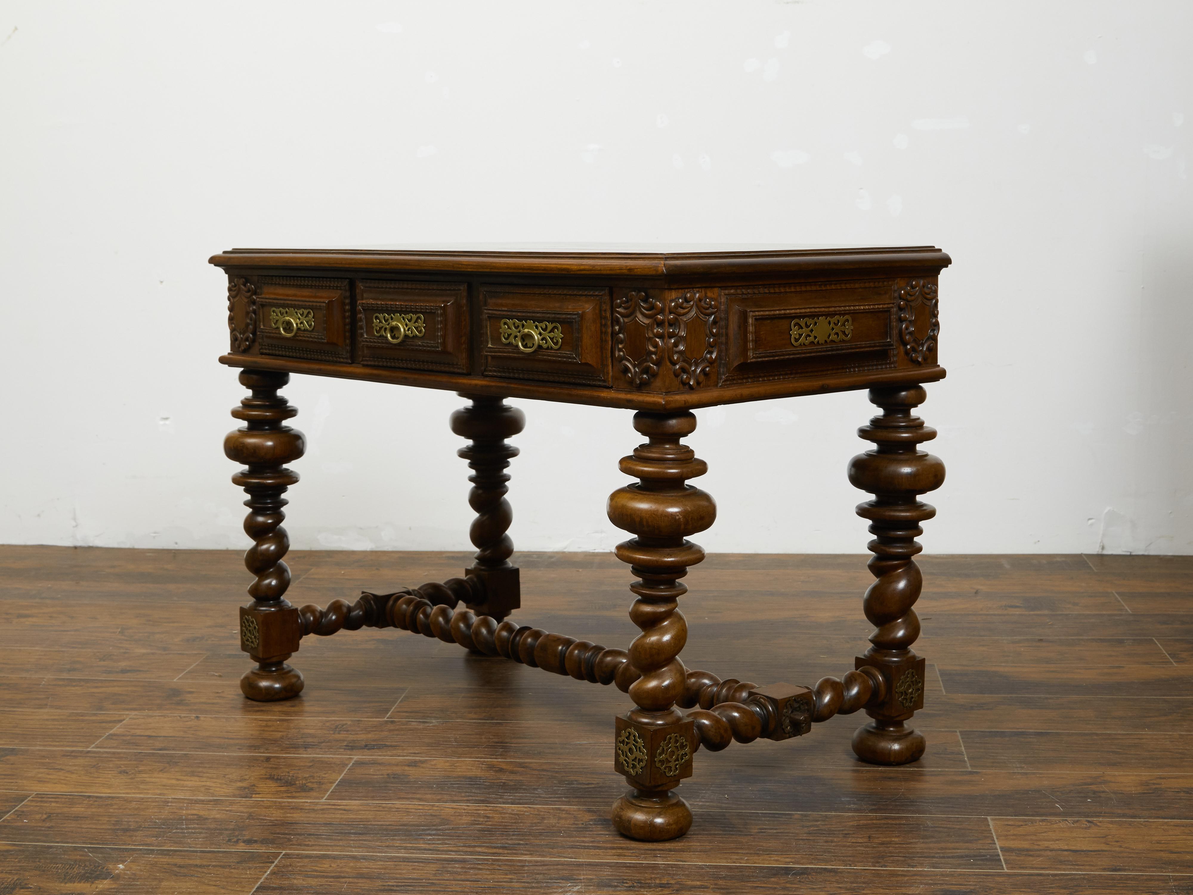 A Portuguese Baroque style table from the 19th century, with barley twist base and ornate brass hardware. Created in Portugal during the 19th century, this Baroque style table features a rectangular planked top sitting above three drawers with