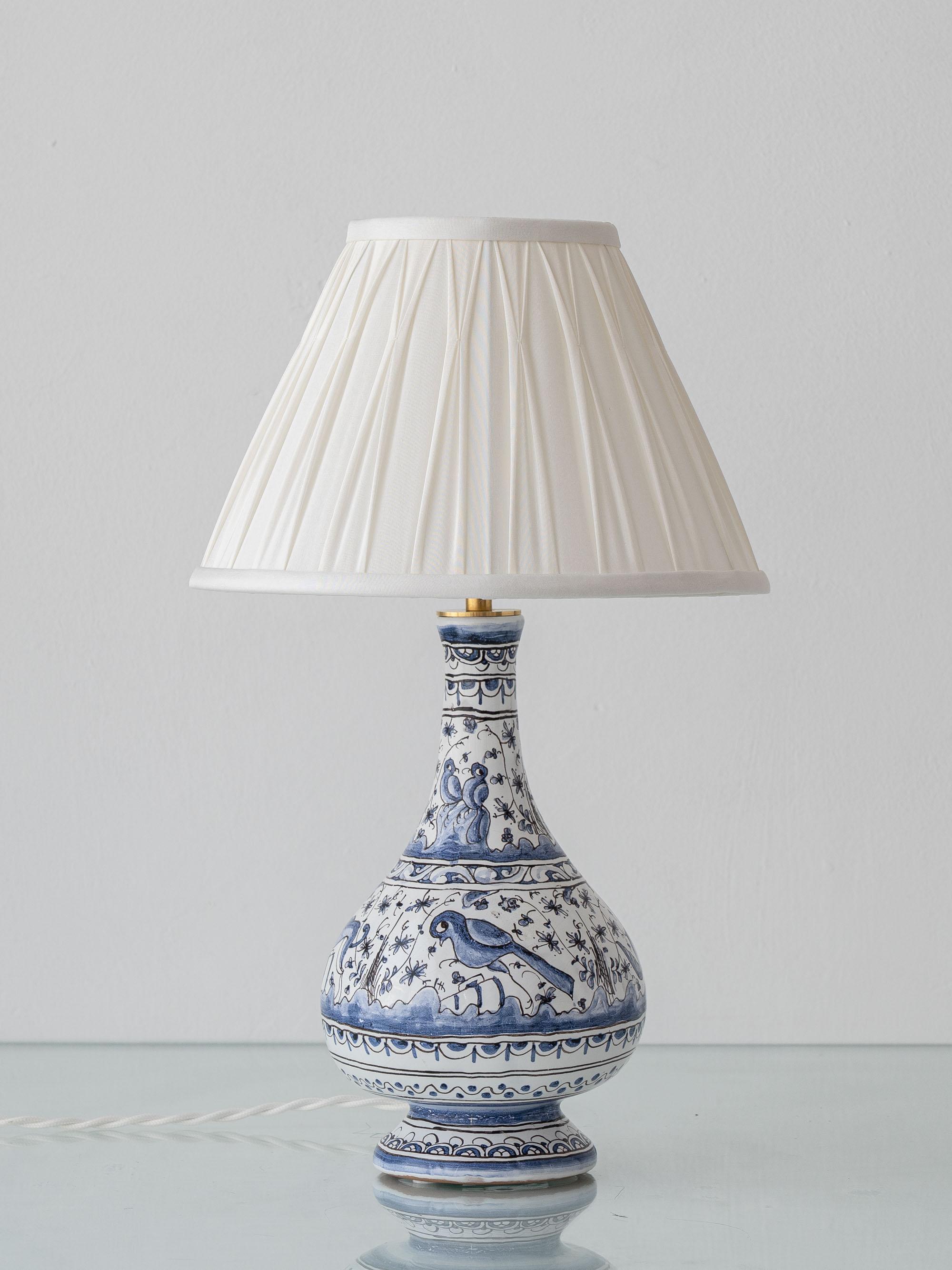 Fabriquée à la main par le Studio Whiting à partir d'un vase en faïence portugais peint à la main (milieu ou fin du XXe siècle, Coimbra, renouveau du XVIIe siècle), cette lampe de table en céramique bleue et blanche est une pièce unique. La forme
