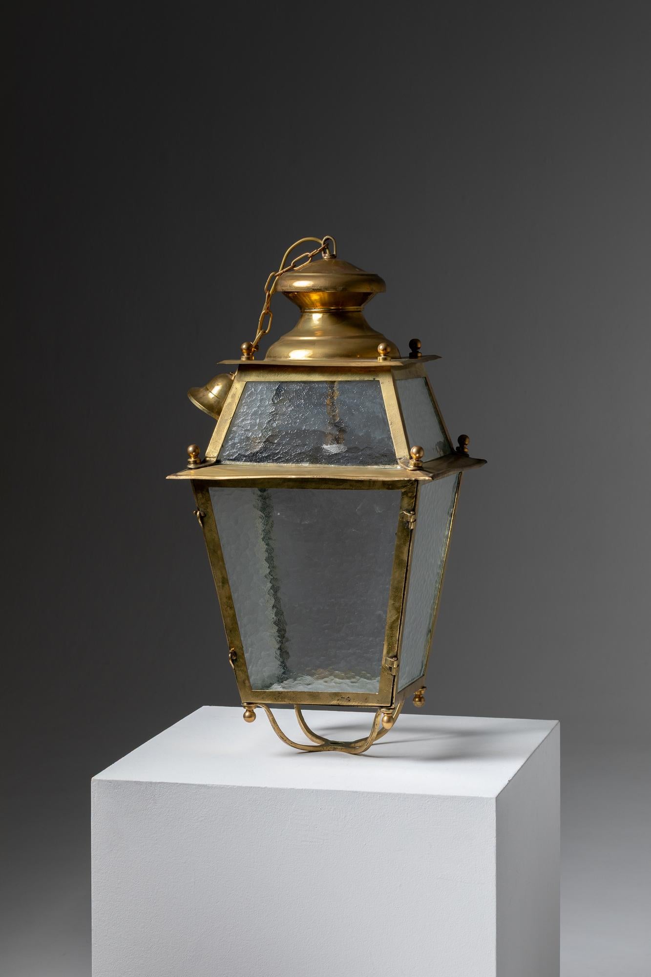 This is a beautiful Portuguese brass lantern, dating from around 1950. The lantern has an elegant four-sided (quadrilateral) shape, with slightly tapered panels that give it a refined and classical appearance. The frame is made of polished brass,