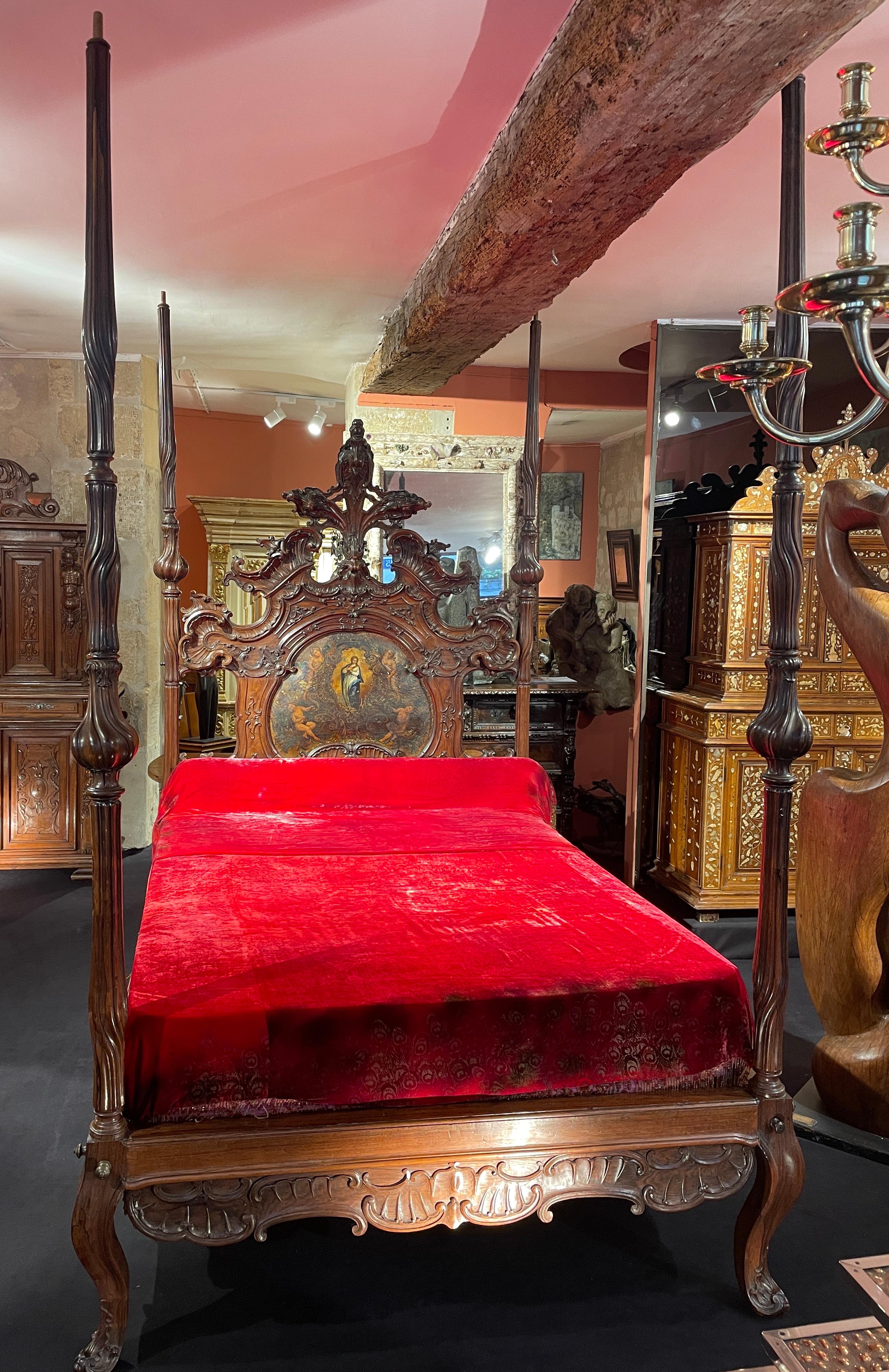Rare Canopy bed in mahogany, richly carved with palm leaves, foliage and plants. The headboard is decorated with a nice painting representing the Virgin surrounded by putti. The four uprights of the canopy are carved with spiral moldings and finish