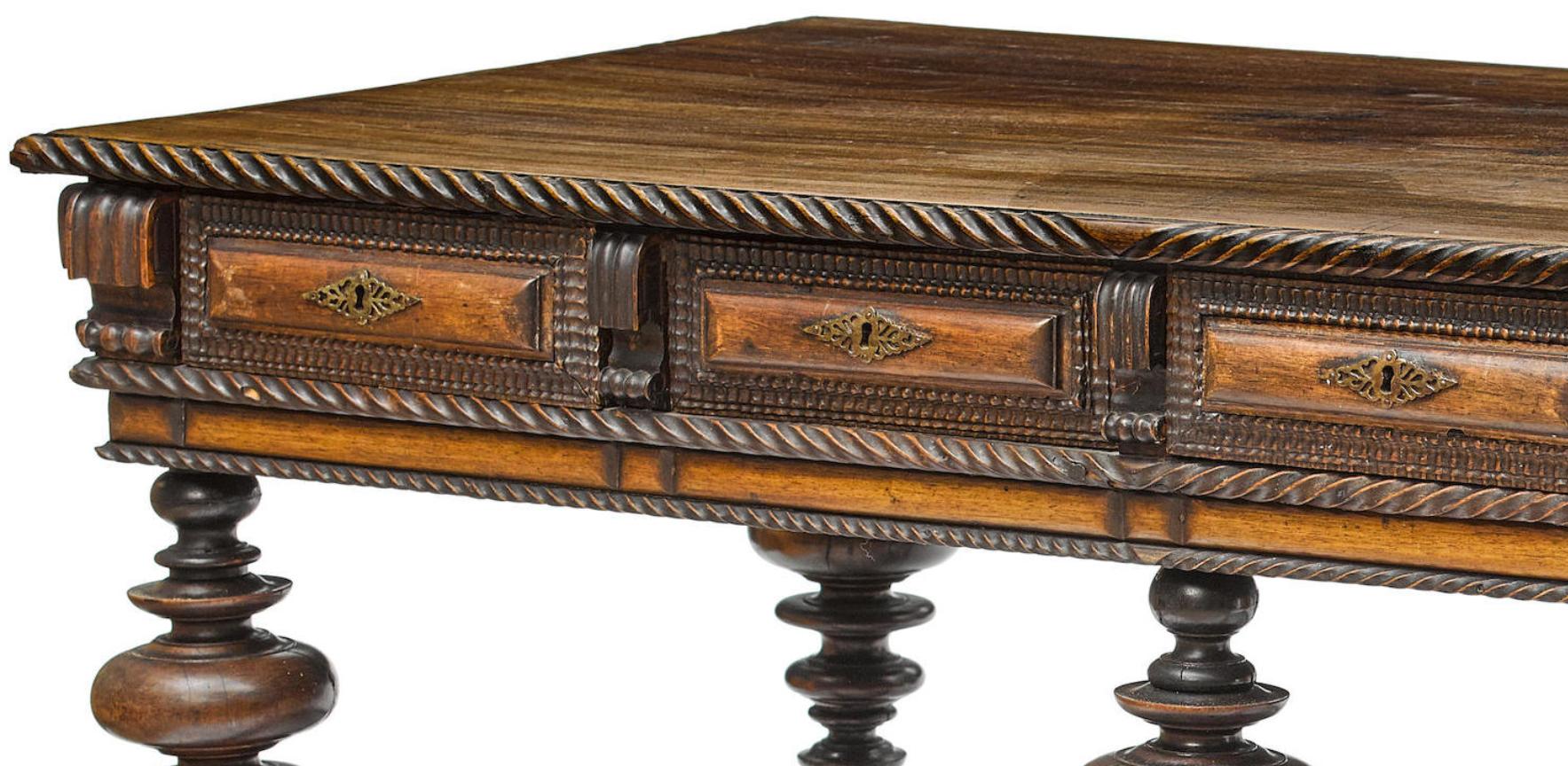 Imposing Portuguese hand carved Jacaranda center table, late 18th-early 19th century.
The rectangular moulded top is with a carved gadrooned border over a frieze fitted with four short drawers and eight sham drawers, all mounted with filigree brass
