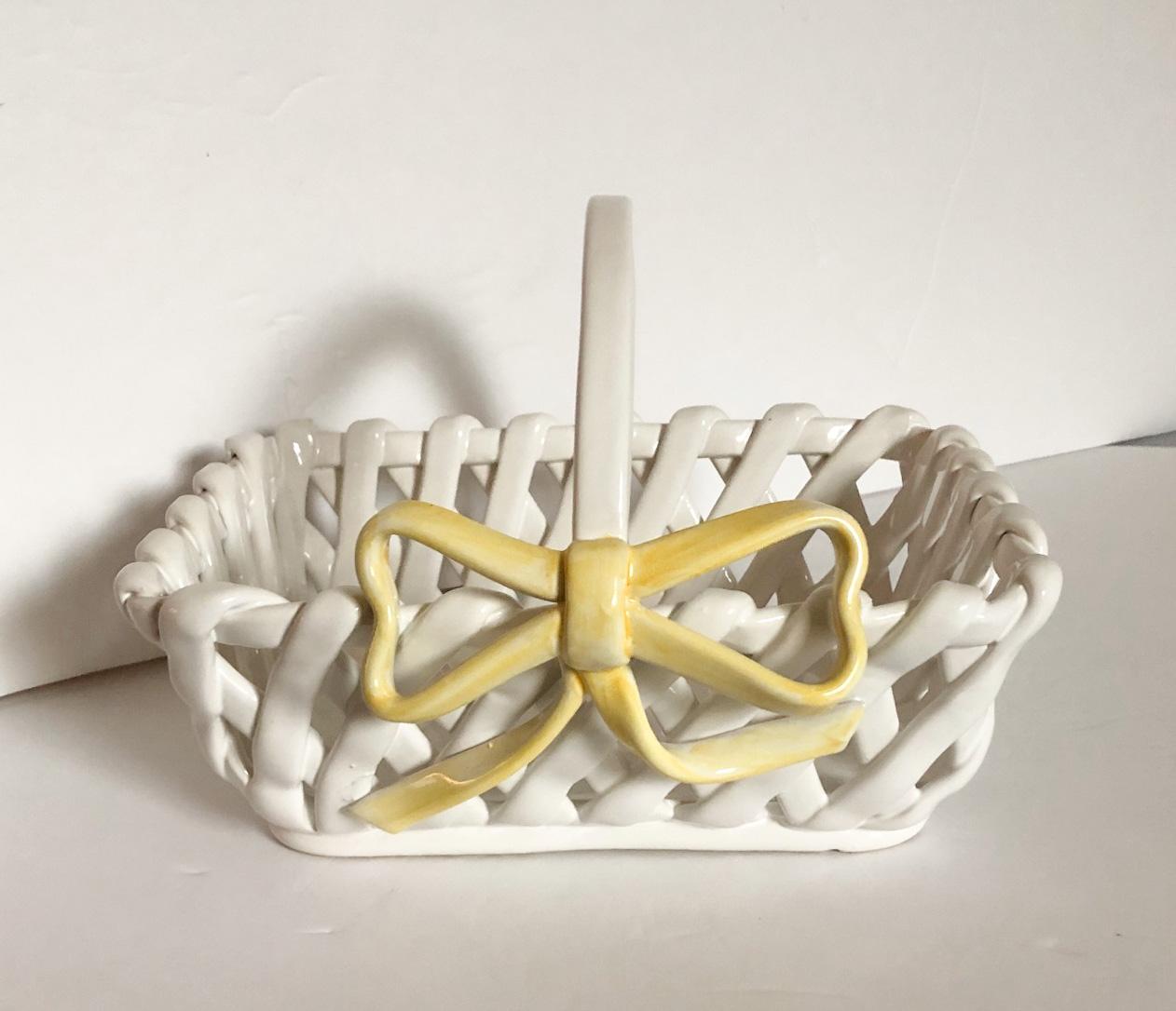 White ceramic woven basket with a yellow bow on the front, made in Portugal.