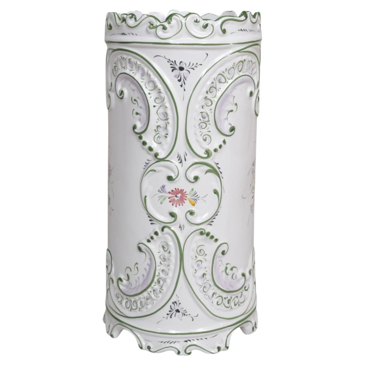 A Portuguese ceramic umbrella stand by RCCL Pottery. Round and embossed, the umbrella stand is hand painted with long scrolls and floral sprays. The rim and foot are decorated with a serpentine edge. Marked underneath ‘Handpainted RCCL