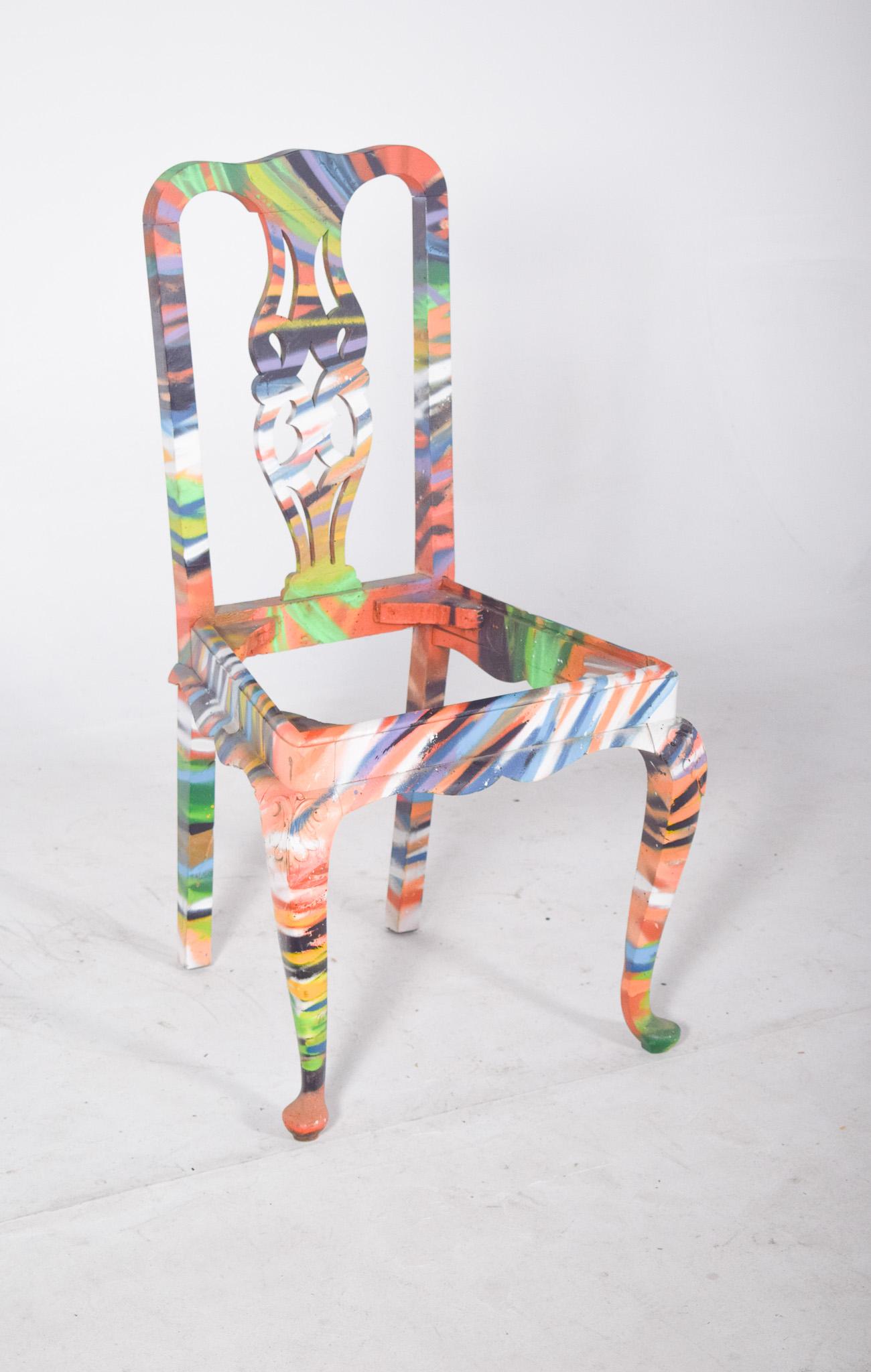 Chaise de salle à manger avec dossier haut, peinte. Style classique avec un dos creux et des pieds cabriole, transformé en une pièce vibrante d'art urbain contemporain. L'intervention artistique recouvre toute la surface d'éclats de couleurs dans