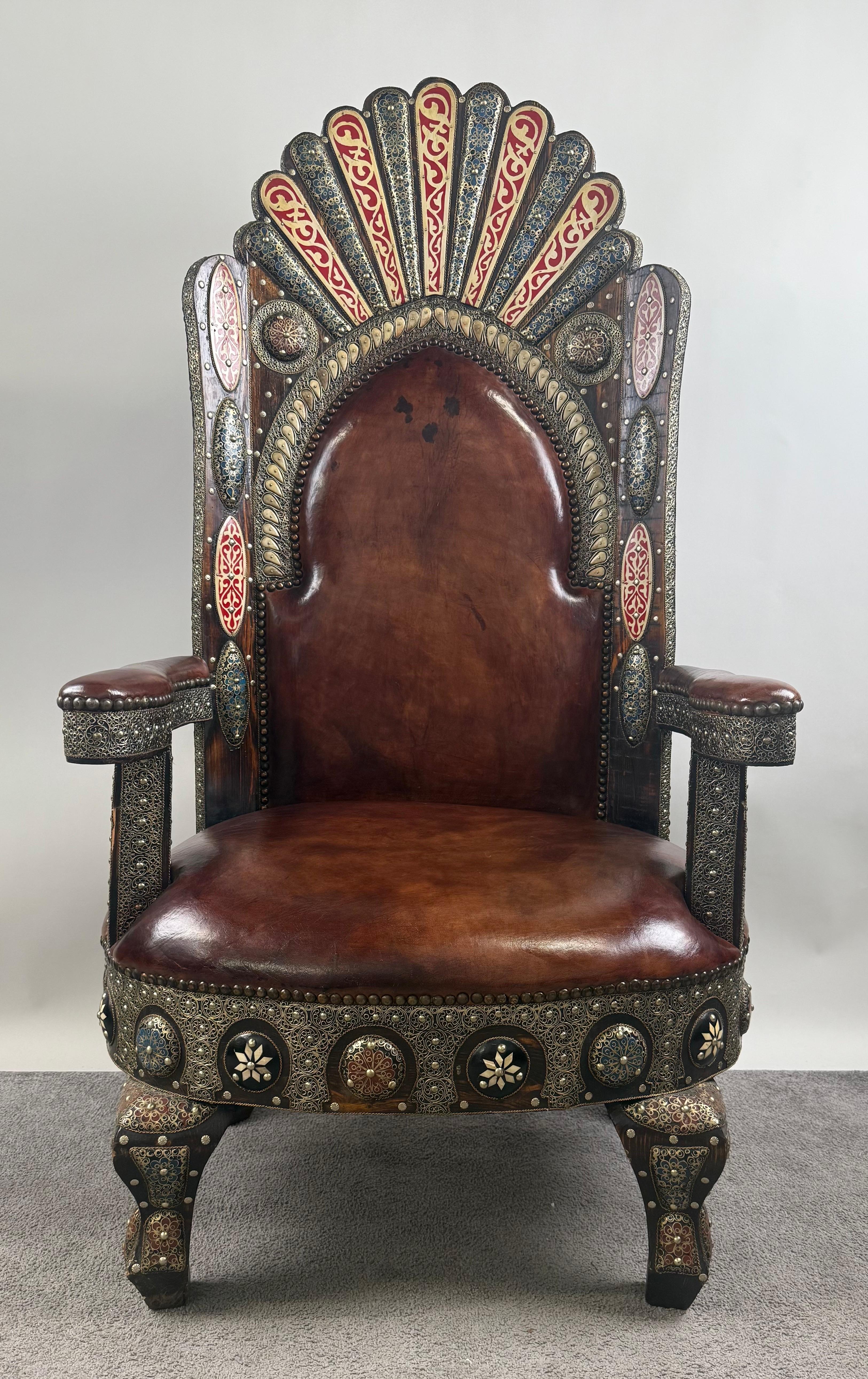 Portuguese Colonial Style Leather & Filigree Design Throne Chair :  This magnificent armchair is a striking embodiment of regal opulence and artisan mastery. Its stately silhouette is defined by a commanding high back, crowned with a radiant fan