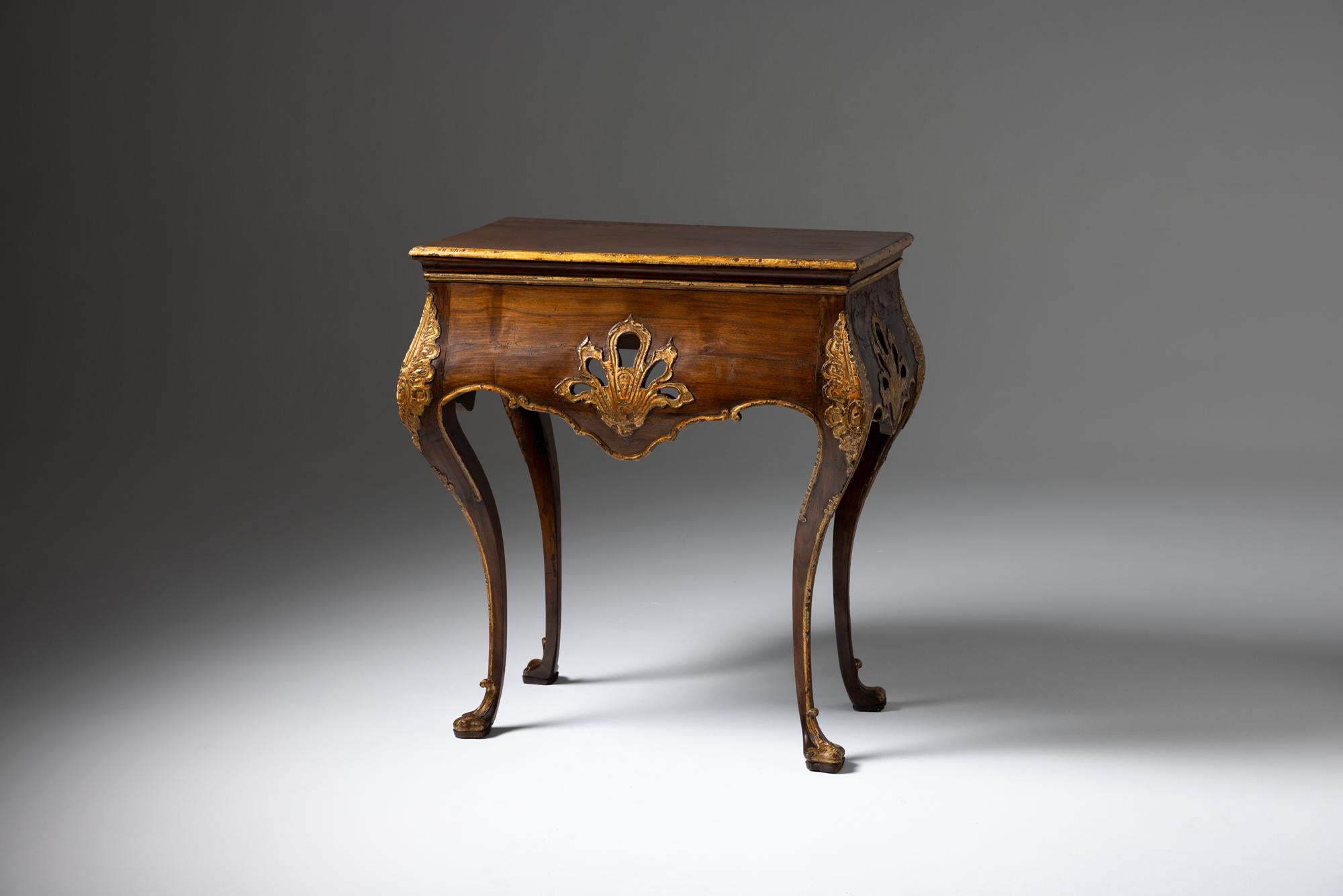 This exquisite Portuguese credenza, dating from the 18th century during the reign of King João V, is a stunning example of period craftsmanship. Made primarily from rich walnut wood, the piece features intricate openwork detailing and partial
