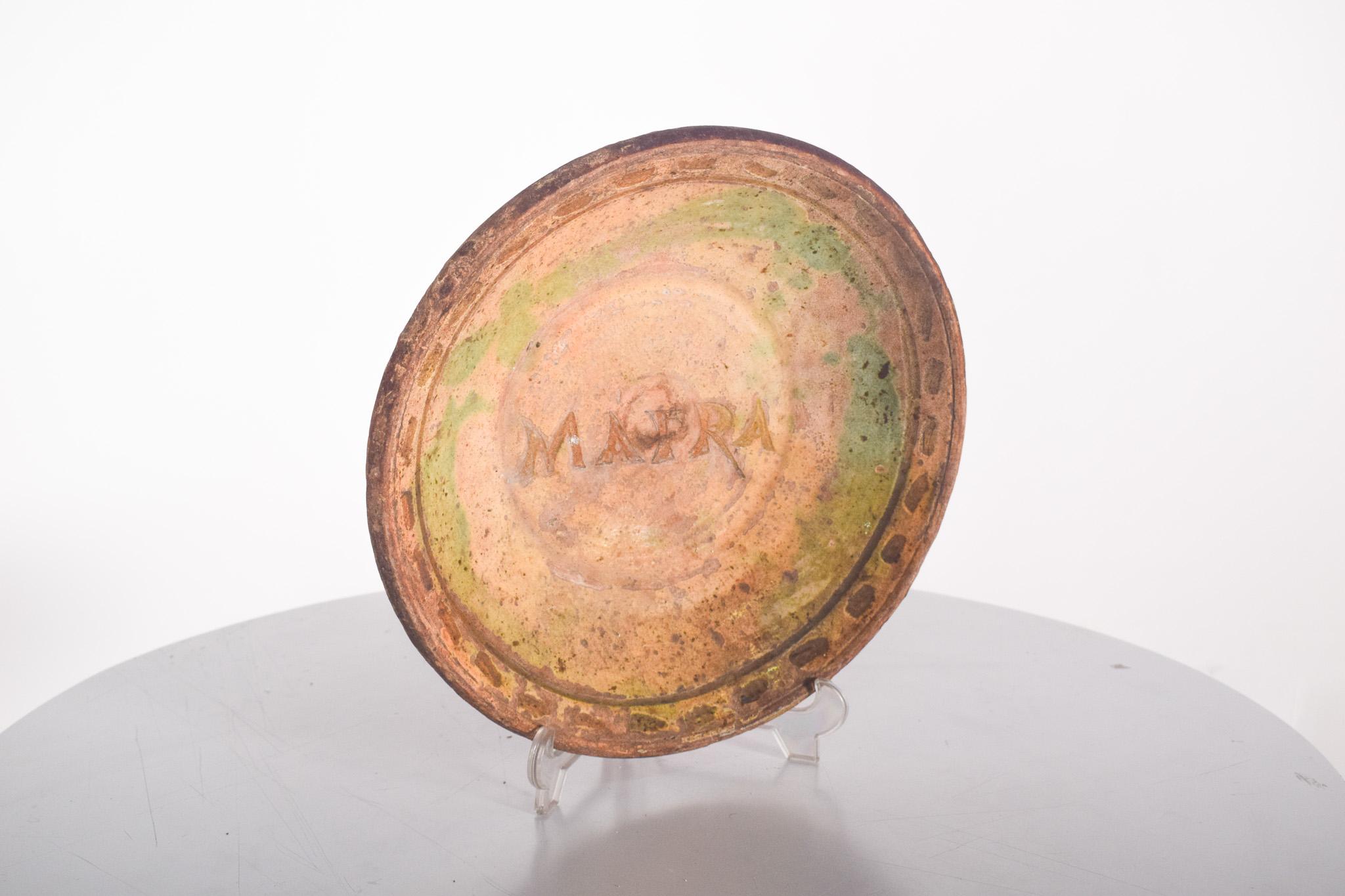 Très usé, il manque des meubles et des couleurs. Décoration polychrome avec l'inscription MAFRA au centre.
Avec une surface émaillée dans des tons terreux, à dominante ocre, verte et jaunâtre, qui font référence à la naturalité des pigments utilisés