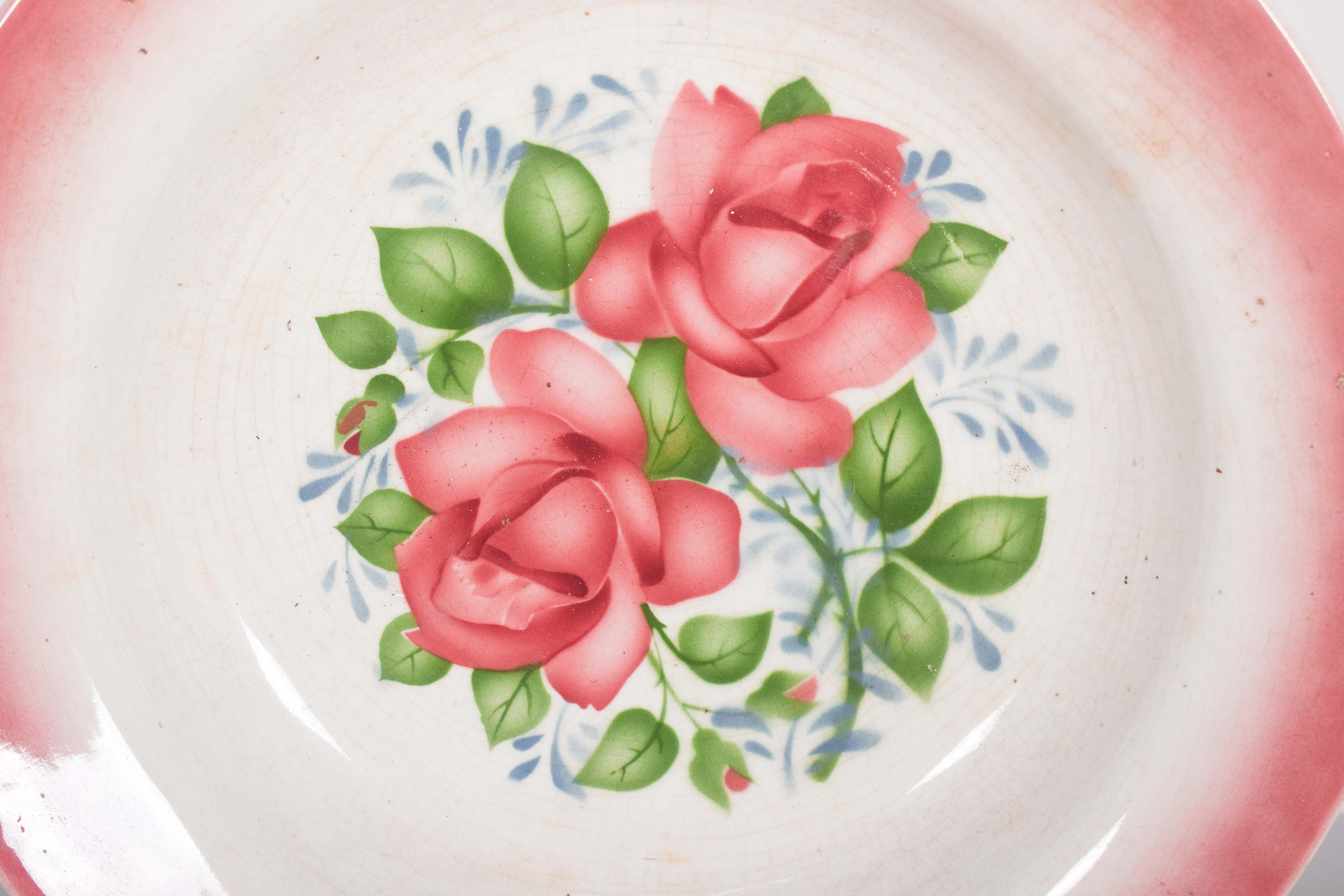 Assiette creuse, en faïence portugaise de Sacavém, Gilman & Cª, Sacavém, Portugal. Décorée d'un motif floral central, composé de deux roses en pleine floraison, peintes avec un doux dégradé, mettant en valeur les volumineux pétales et les feuilles