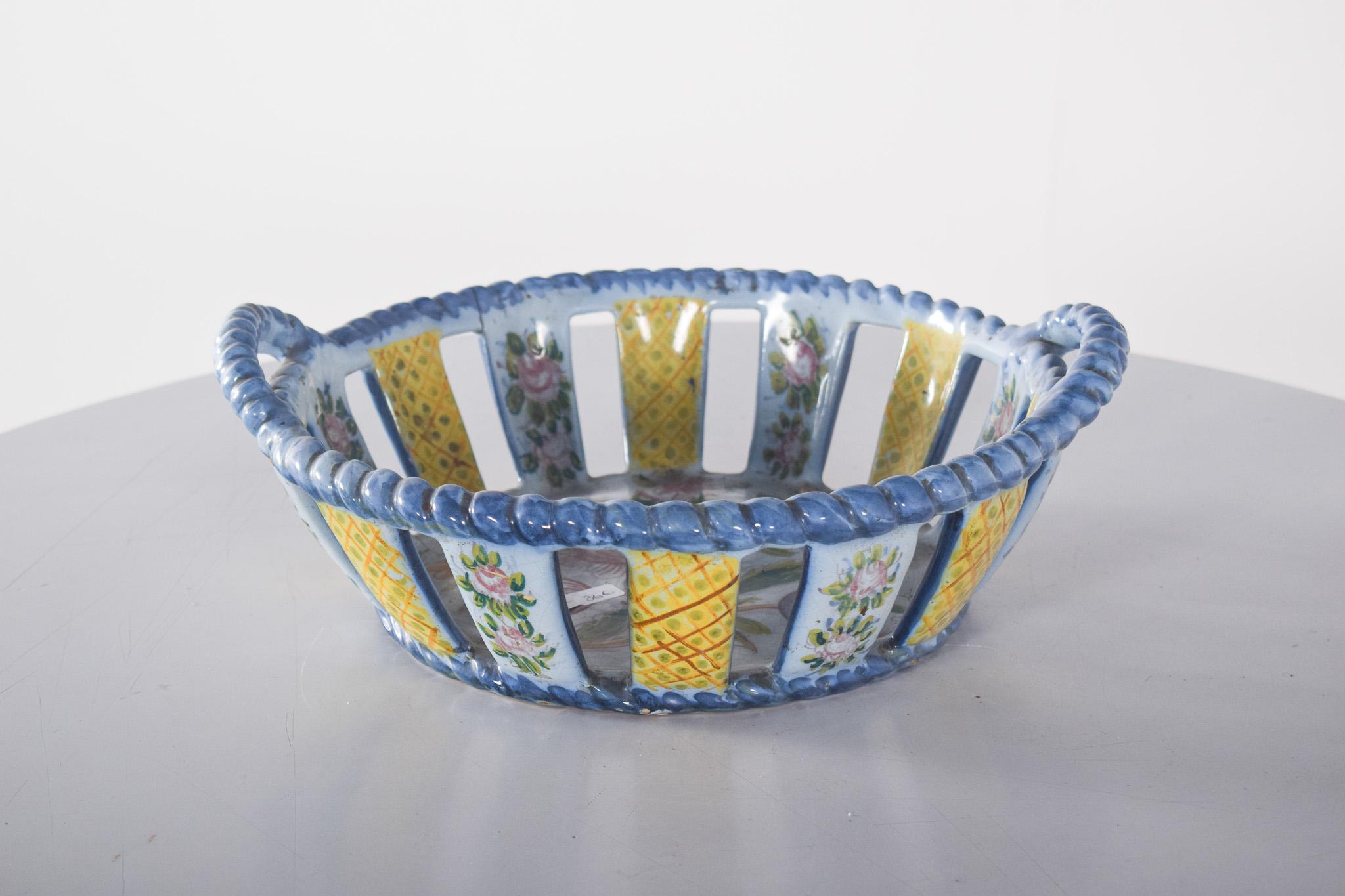 Portuguese earthenware fruit bowl. Polychrome decoration with a wavy blue border that is repeated both inside and out.
The decoration is made up of alternating bars of floral and geometric patterns. The floral sections feature hand-painted yellow
