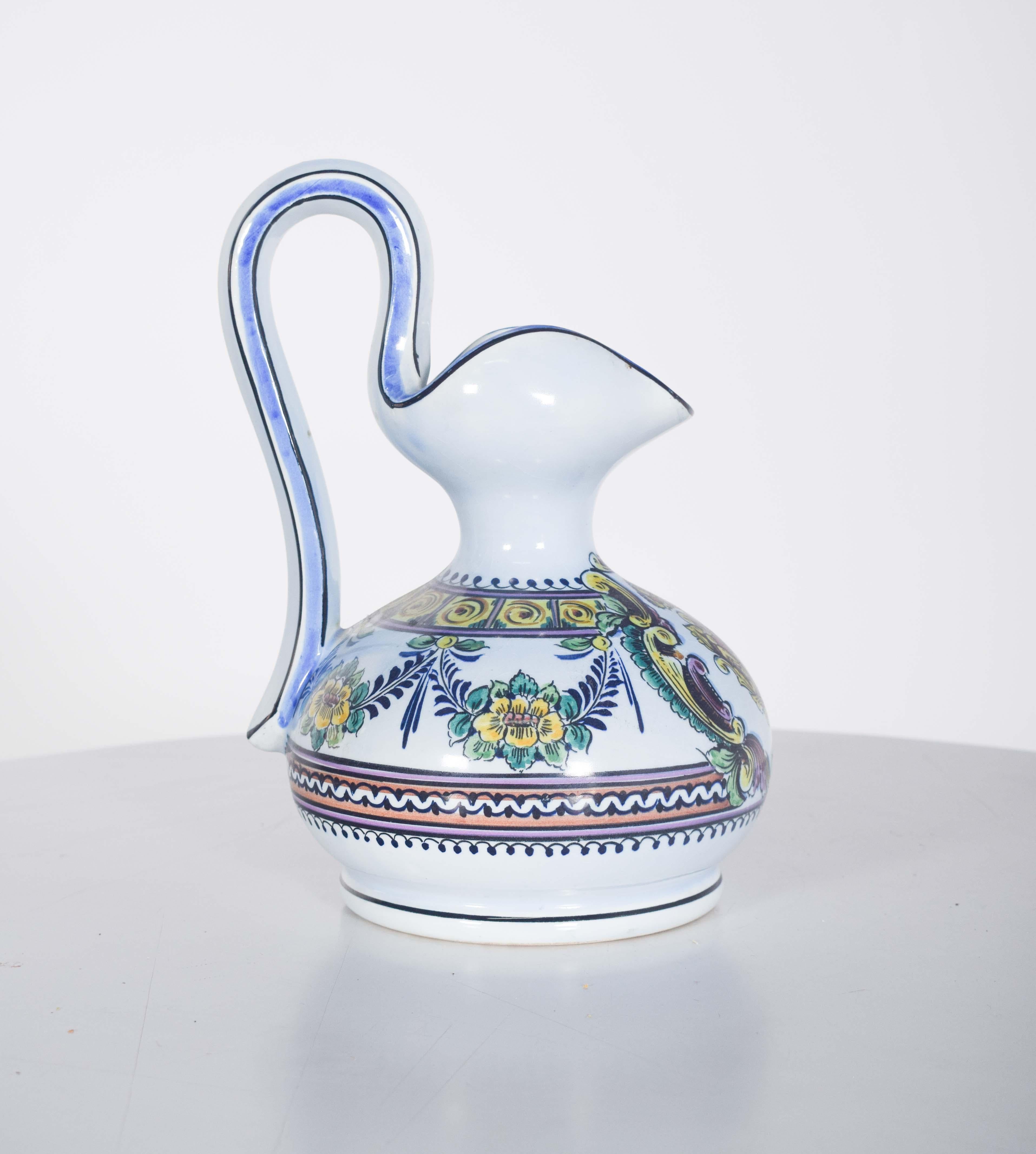 This water jug, in Portuguese faience from Outeiro, is a unique and refined piece that reflects the mastery of the region's ceramists. The polychrome decoration of the piece is rich in details, featuring flowers and leaves delicately painted in