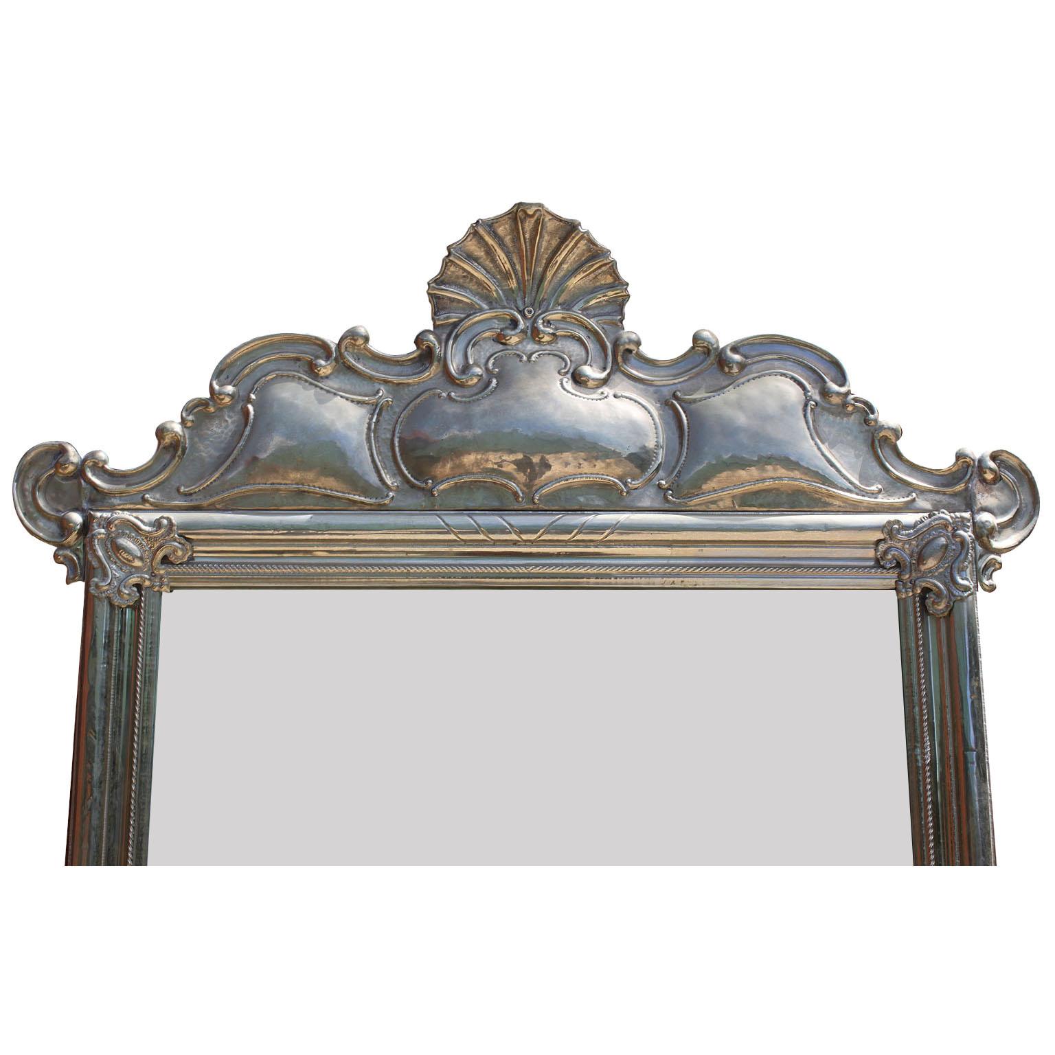 A fine and rare Portuguese embossed Alpaca Silver mirror frame. The elongated frame crowned with a seashell design with a scrolled acanthus trim and corner shields. The bottom with a peacock shaped design with scrolled borders, circa 20th
