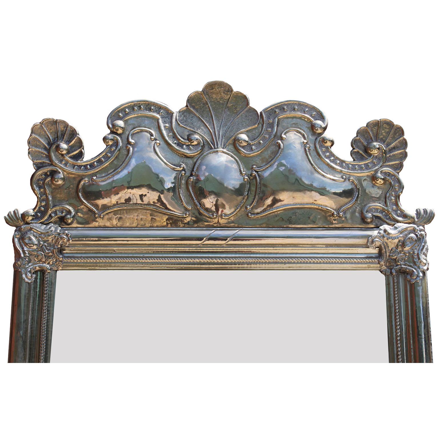 A fine and rare Portuguese embossed Alpaca silver mirror frame. The elongated frame crowned with a seashell design flanked by twin peacock shaped tails with a scrolled acanthus trim and corner shields. The bottom with a peacock shaped design with