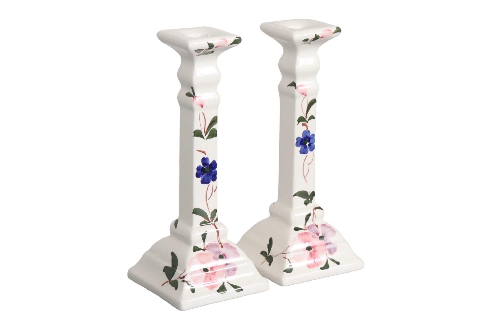 A pair of white ceramic square candlestick holders. Brightly decorated on opposing sides with hand painted trailing pansies in pink, violet and indigo. Made in Portugal. Dimensions per candlestick.
   