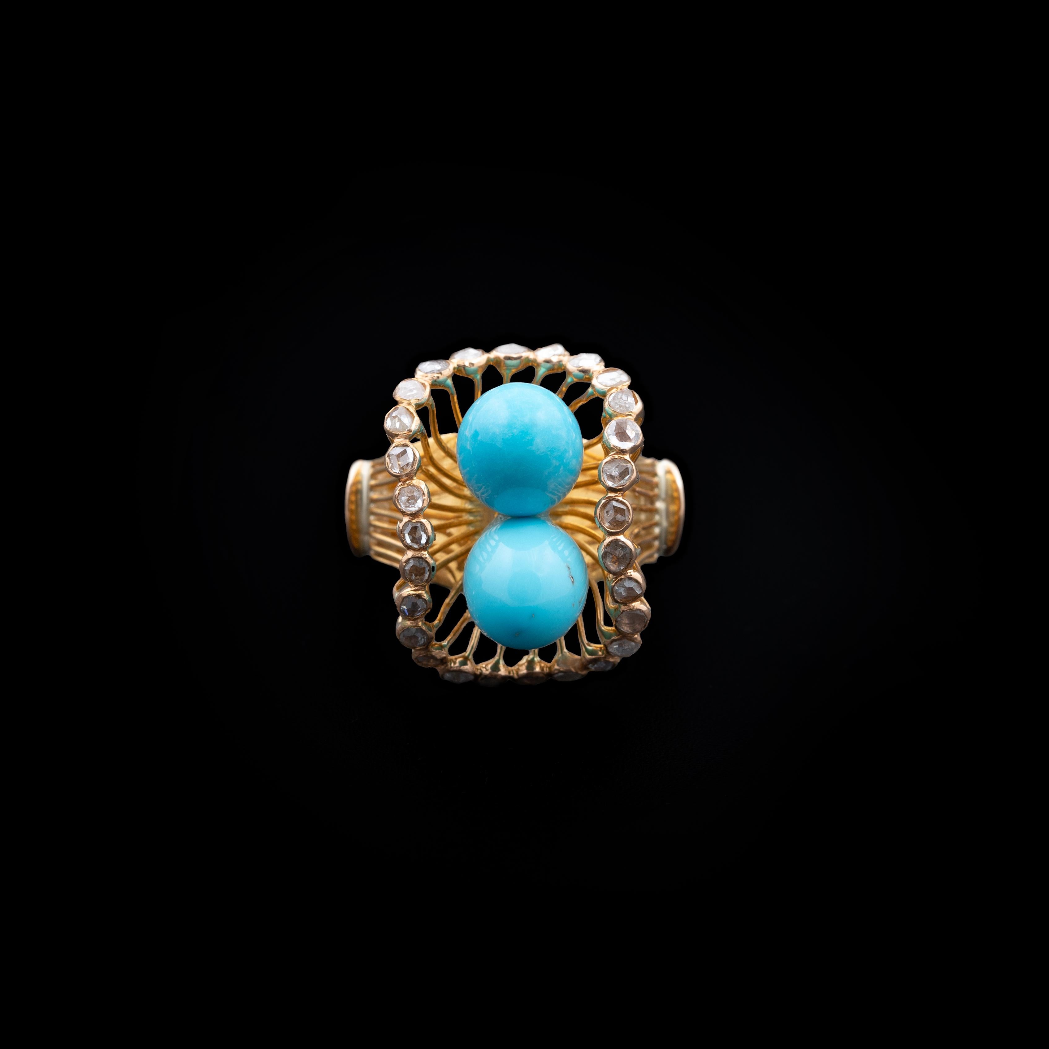 A sculptural and finely crafted Portuguese ring, executed in 800/1000 yellow gold, featuring two cabochon turquoise pearls nestled within an ornate basket-form setting. This architectural mounting elevates the gemstones above the finger in a