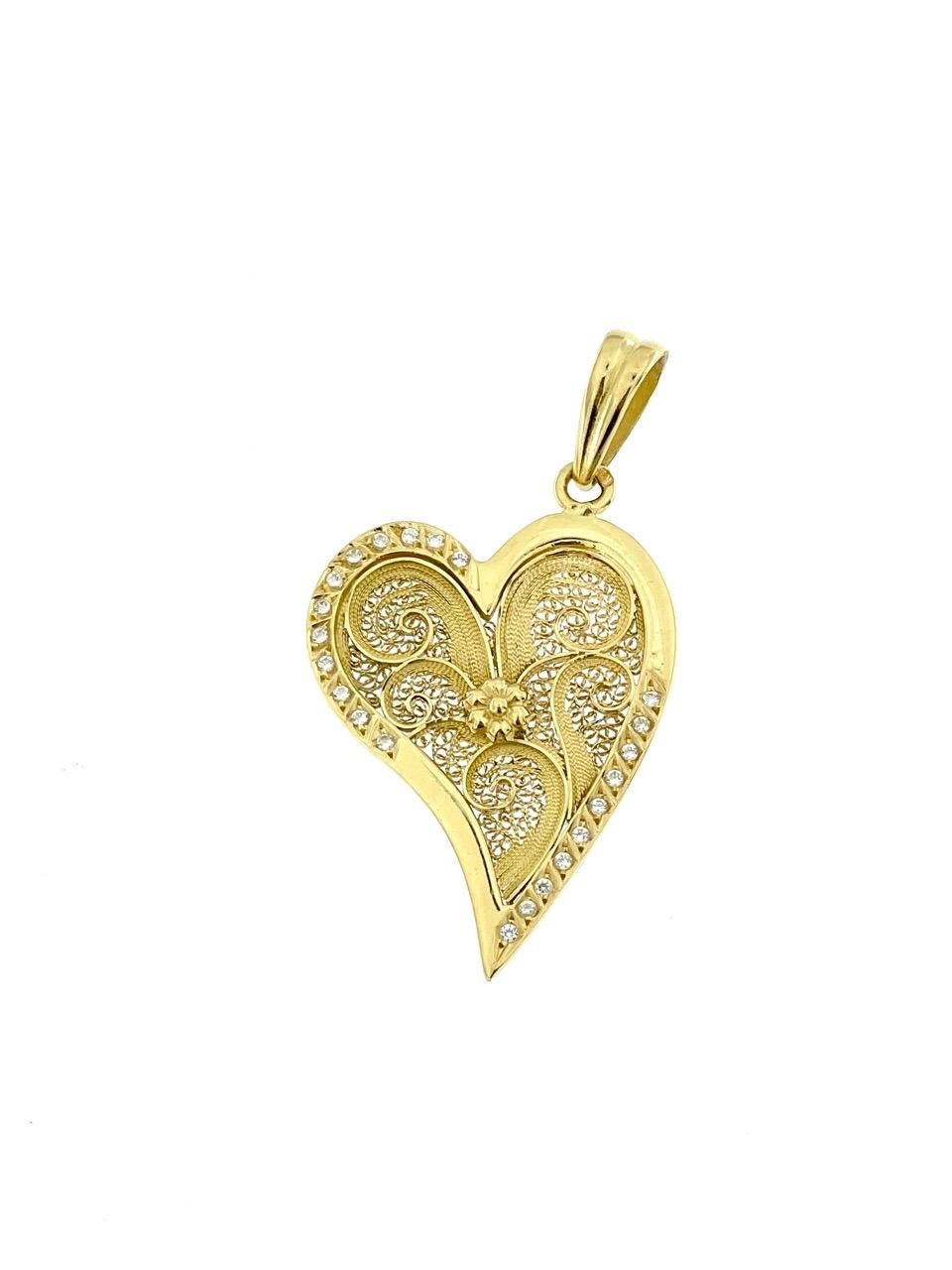 The Portuguese Heart Pendant in Yellow Gold with Zircons is a captivating piece of jewelry that exudes elegance and cultural charm. Crafted with meticulous attention to detail, this pendant features a heart-shaped design, a symbol of love and