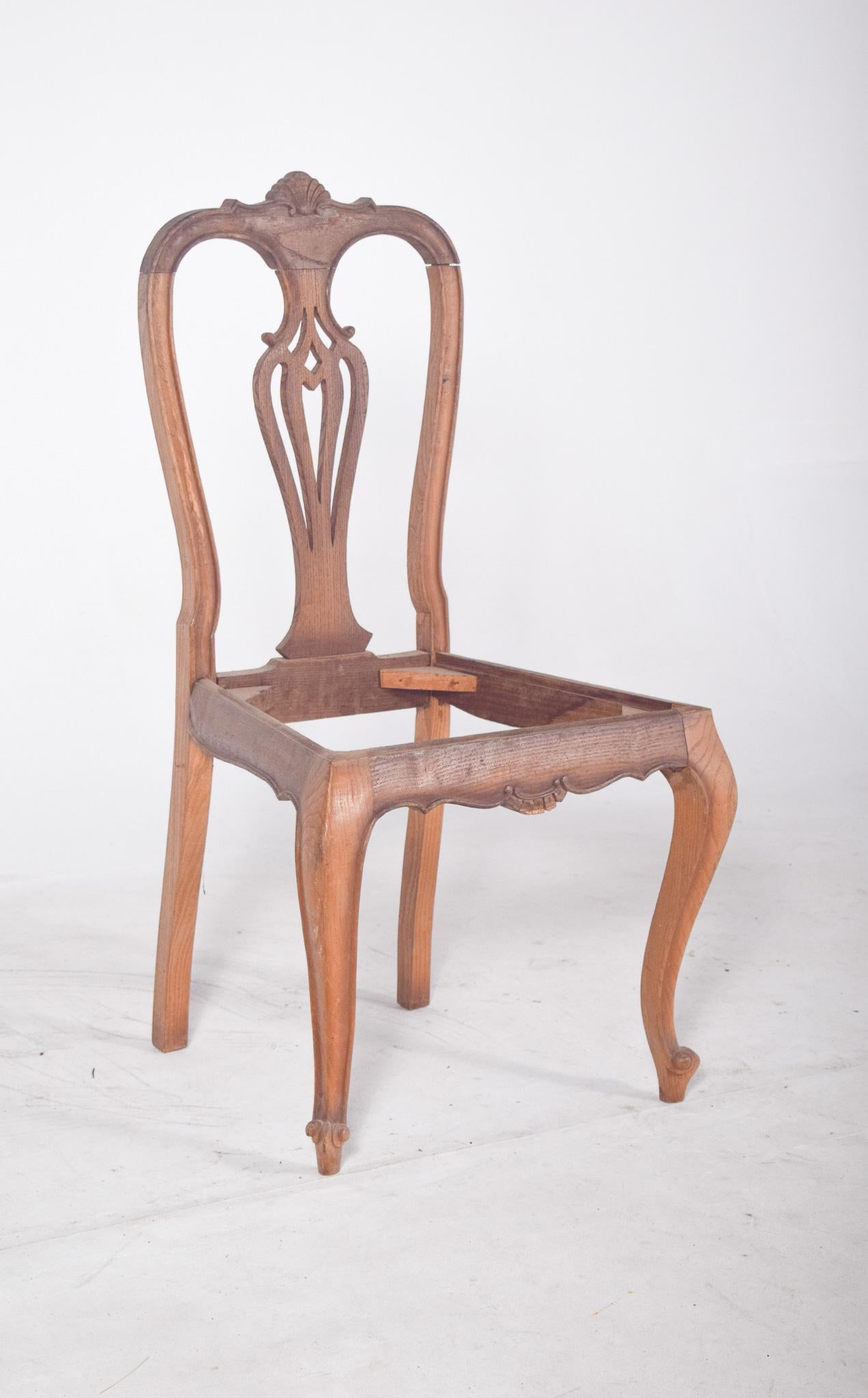 Sedia da pranzo in stile Luigi XV.  Con uno schienale scavato, lavorato con intagli a forma di conchiglia centrati sulla parte superiore e uno schienale scavato con un disegno simmetrico a pizzo. Le gambe anteriori sono a forma di cabriolet,