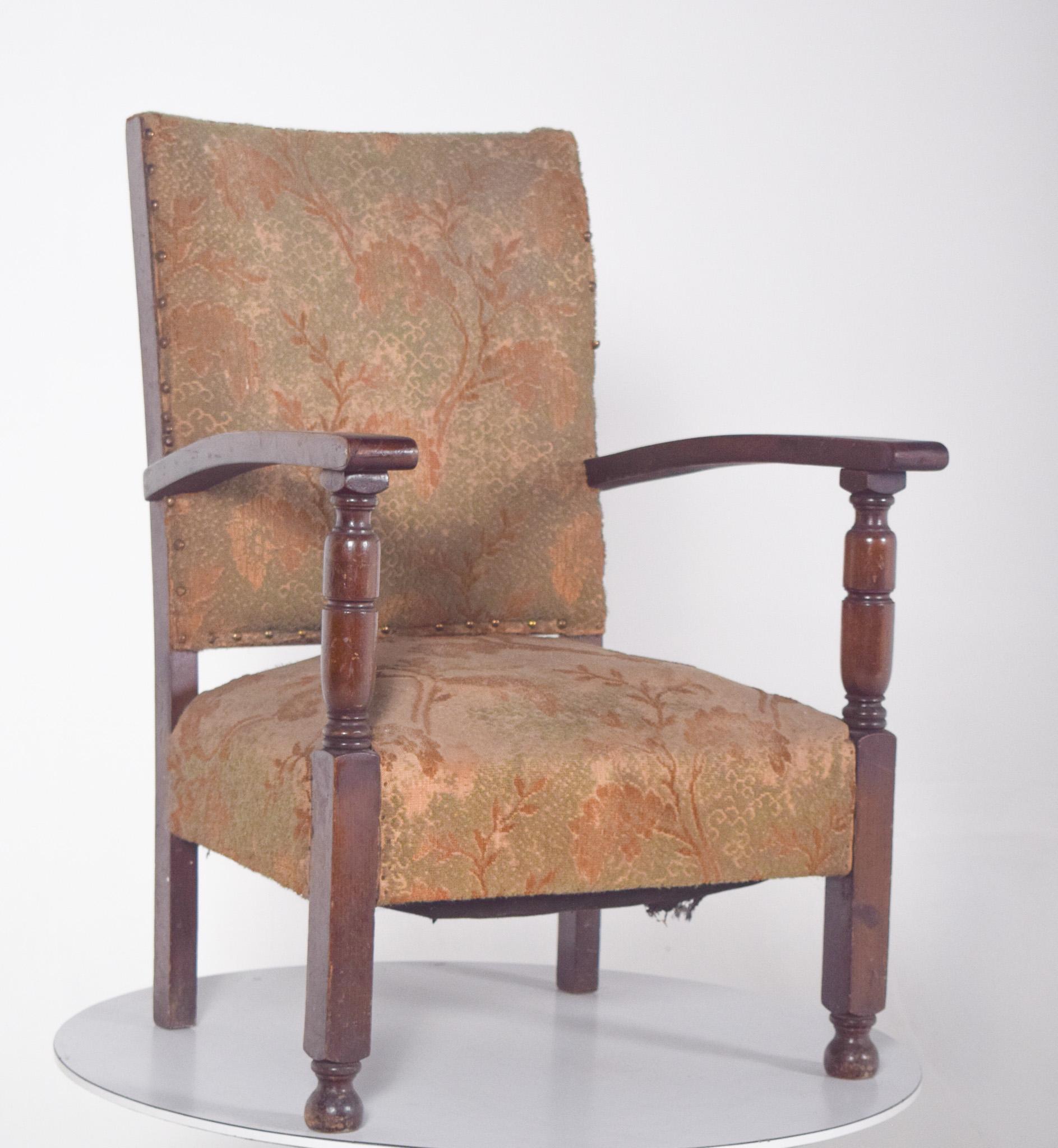 Fauteuil bas avec dossier et assise tapissés. Le dossier et l'assise sont généreusement proportionnés, enveloppant confortablement le corps, tandis que les accoudoirs, également en bois, présentent une légère courbure aux extrémités pour une