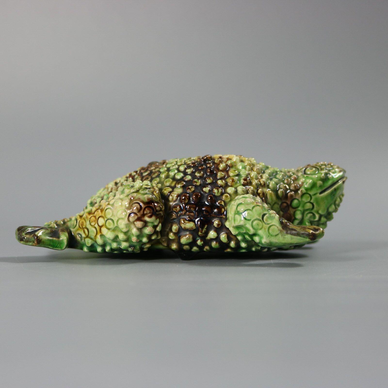 Figurine en majolique portugaise Palissy représentant un crapaud. Trous d'accrochage au mur à l'arrière. Ces figures peuvent être fixées au mur. Coloration : le vert et le brun sont prédominants.