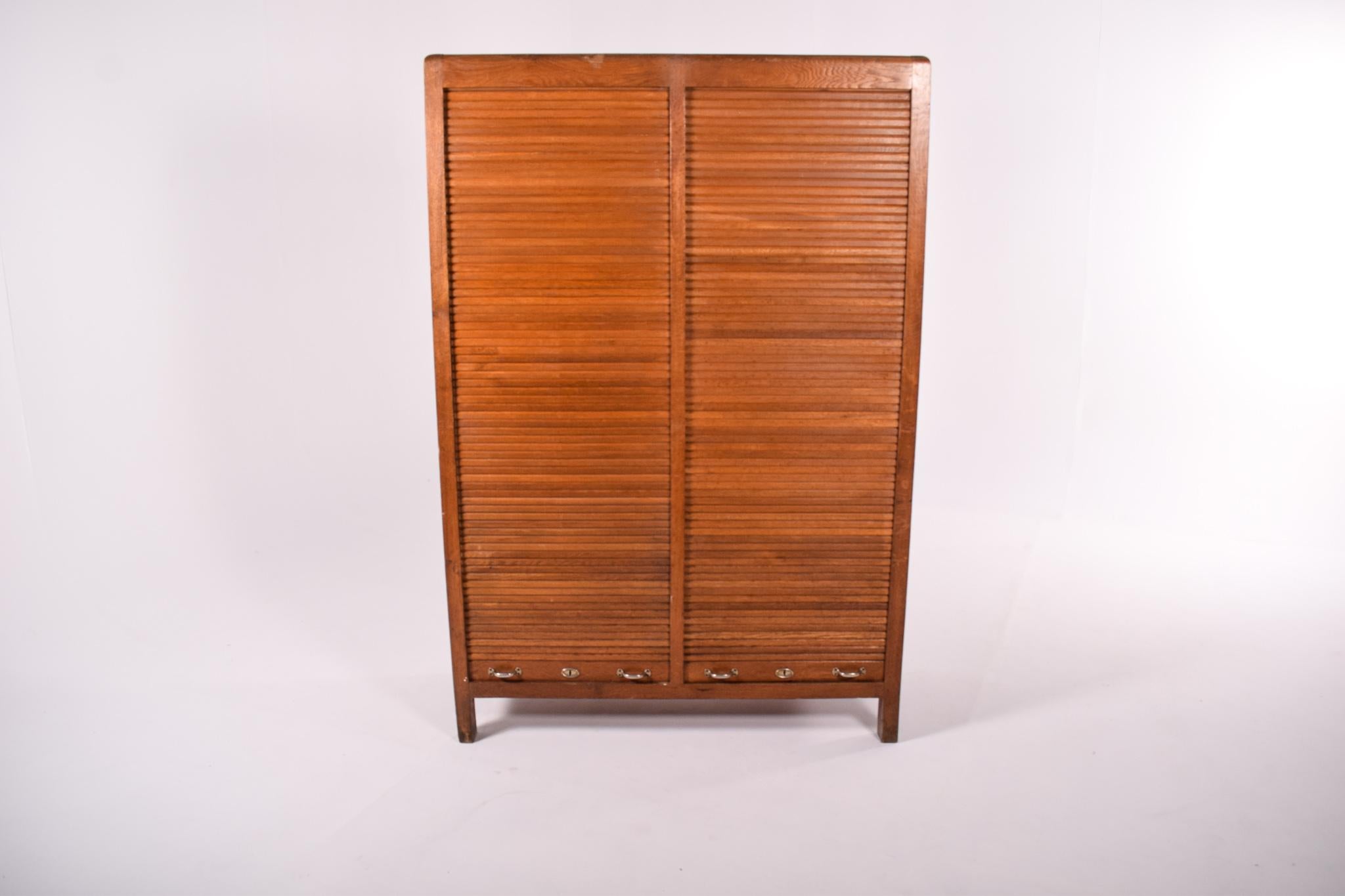 Este armario vintage de roble de los años 50 es una pieza de mobiliario clásico de mediados de siglo con un marcado estilo portugués, fabricado por la prestigiosa empresa Olaio. El diseño del armario es a la vez elegante y práctico, con una robusta