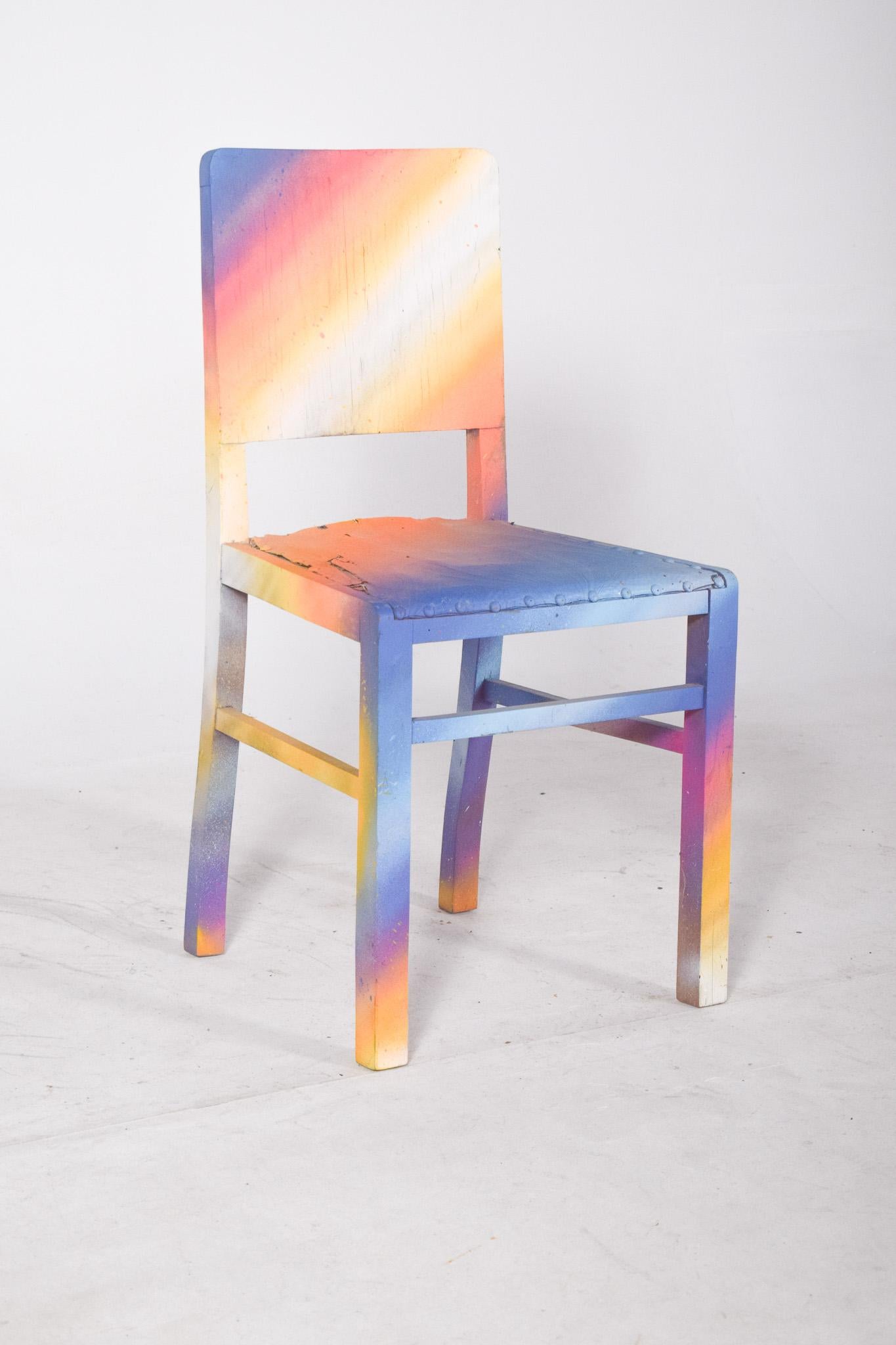Chaise de salle à manger peinte. Doté de lignes simples, il a été remis au goût du jour avec une peinture contemporaine dans des tons dégradés qui évoquent un coucher de soleil. La palette de couleurs passe par des transitions douces entre le bleu,