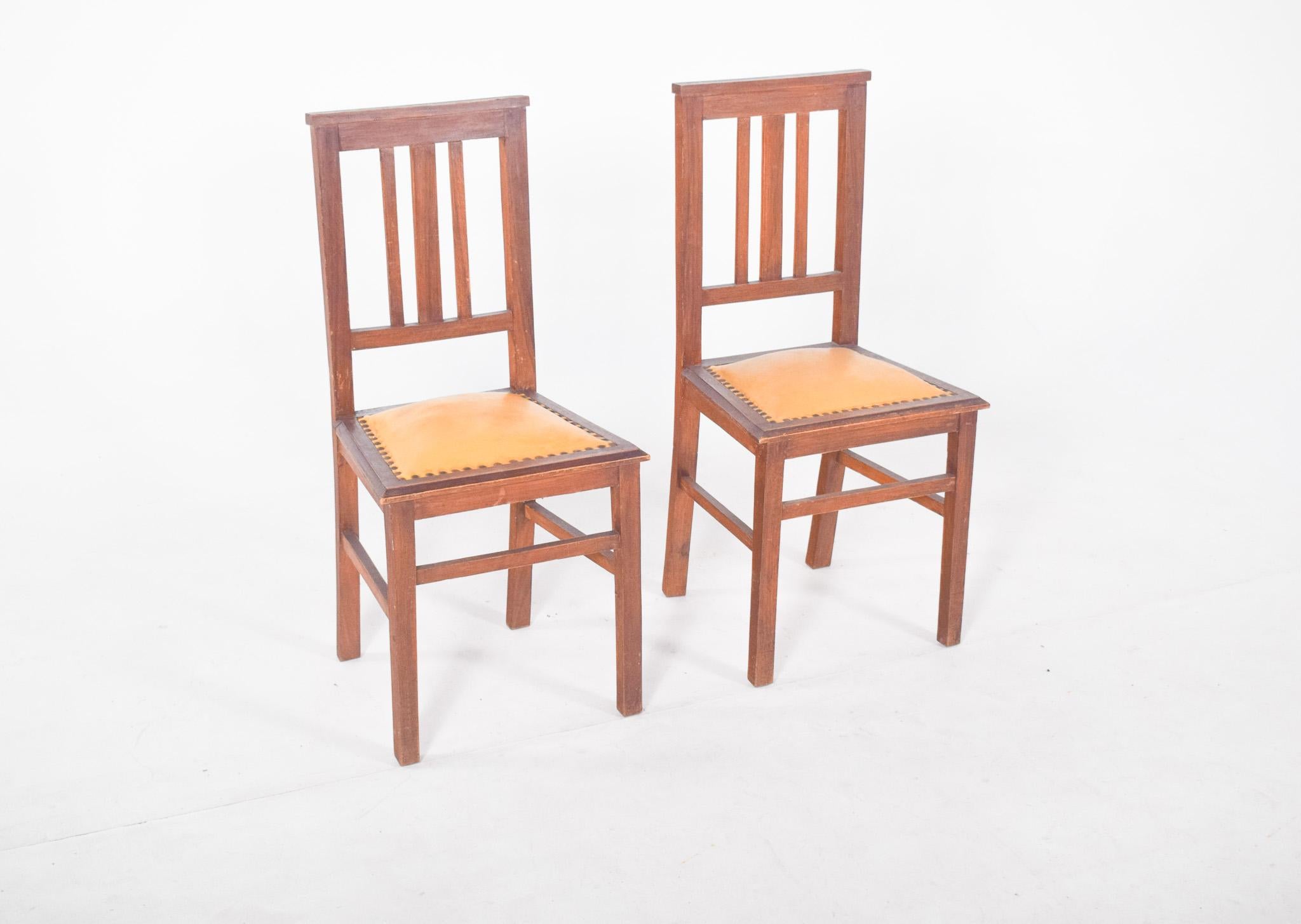 Pair of chairs with yellow upholstery. The design is simple and functional, with a straight structure and side and front reinforcements on the supports, the square-shaped seat is in reasonable condition, although with visible signs of use and wear