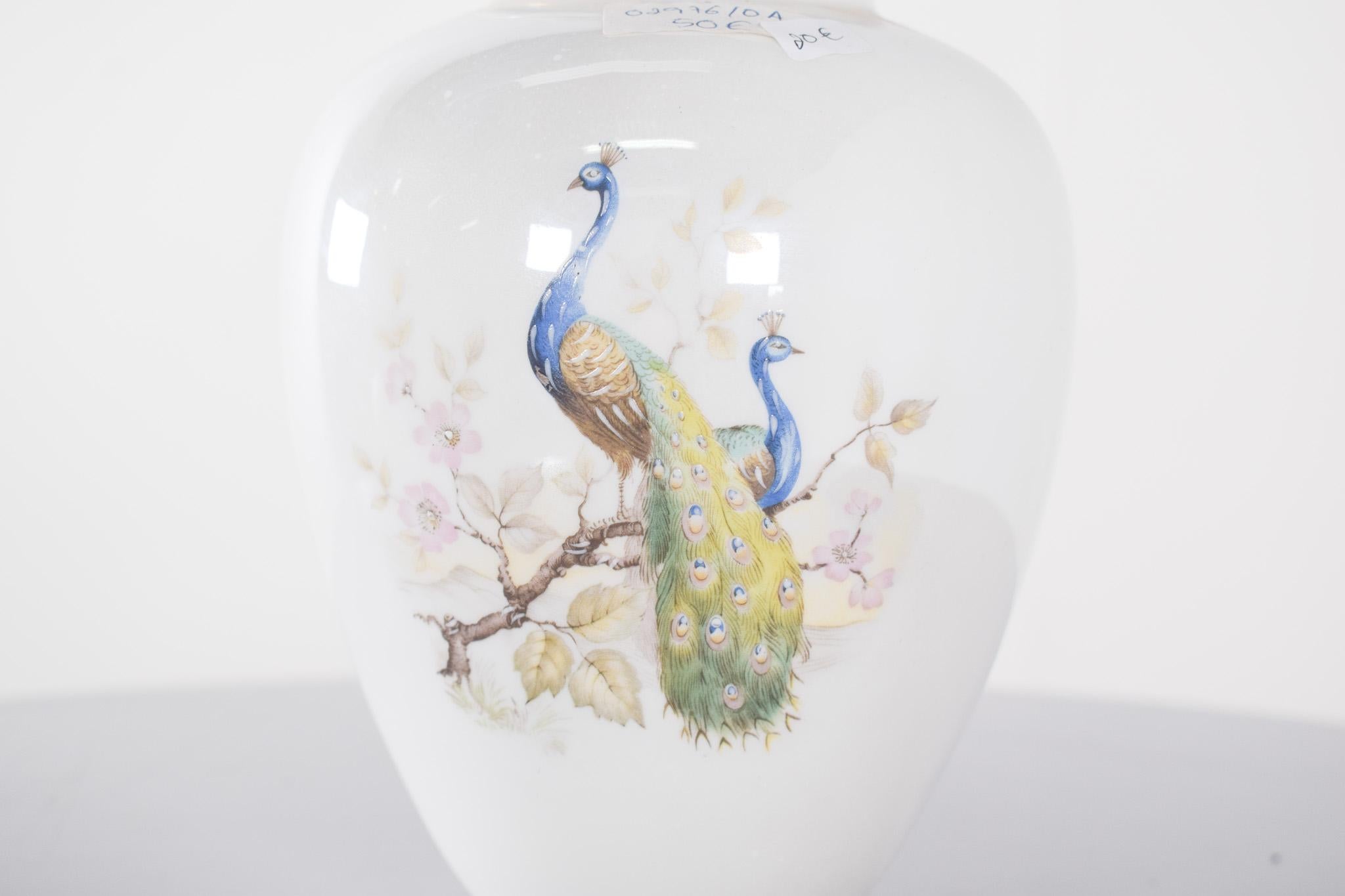 Vaso in porcellana portoghese proveniente da Coimbra, SP.  Decorazione policroma con pavoni, uno degli uccelli più simbolici dell'arte decorativa, che rappresentano bellezza e prosperità. Il pezzo è di colore bianco, con una finitura lucida e