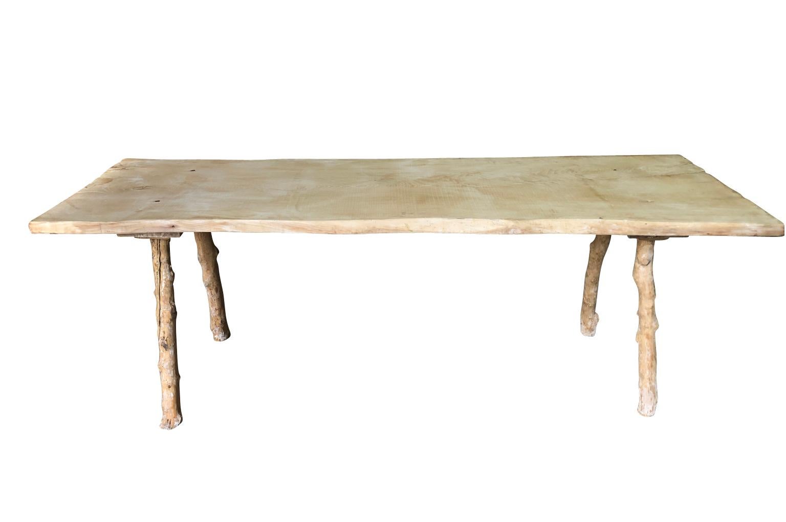 A charming and primitive 19th century farm table from Portugal wonderfully constructed from a solid board top of washed oak and olive trunk legs.