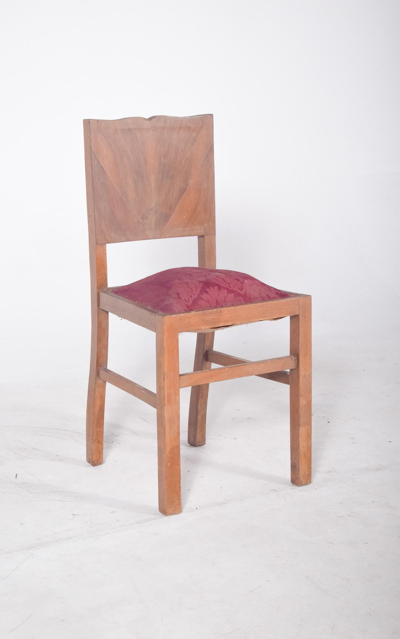 Sedia da pranzo imbottita in rosso. Linee semplici, con schiena dritta e top leggermente tagliato. La superficie dello schienale è realizzata in impiallacciatura con un design a spina di pesce, che conferisce al pezzo un discreto effetto decorativo.