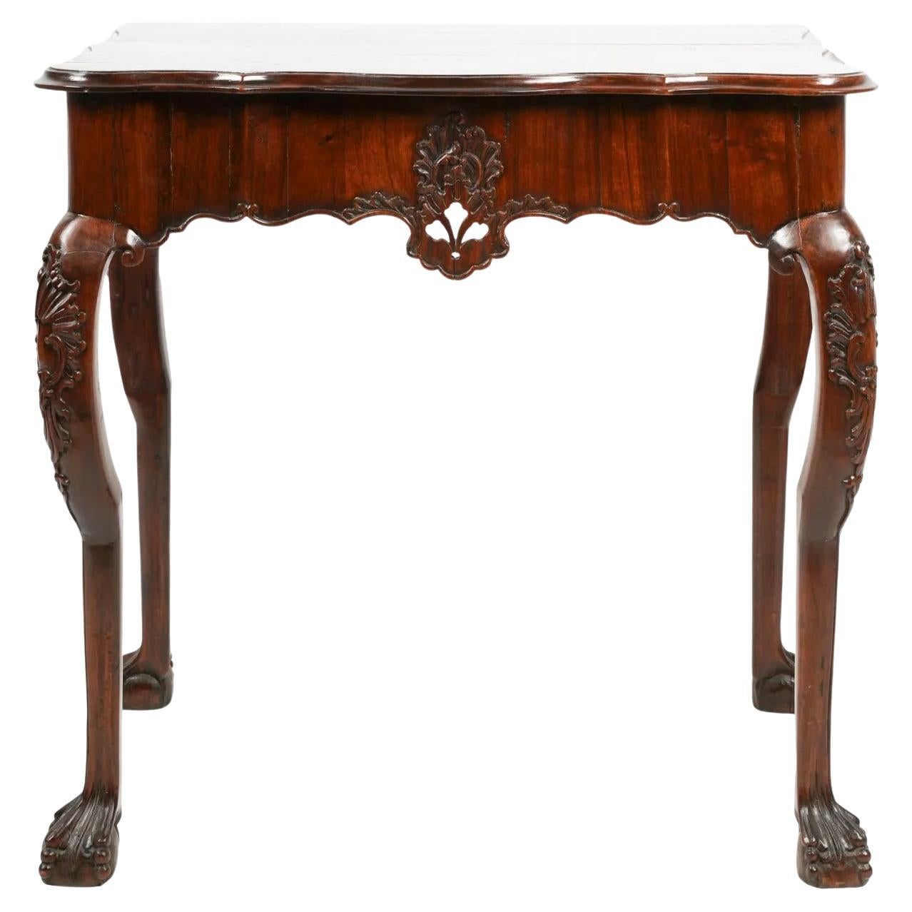 18th century Portuguese Rococo Console made of Brazilian Rosewood. The eared serpentine top above a shaped frieze carved all around with scrolling and cartouche decoration. Standing on big handsome carved ball and claw feet. With a deep rich patina,