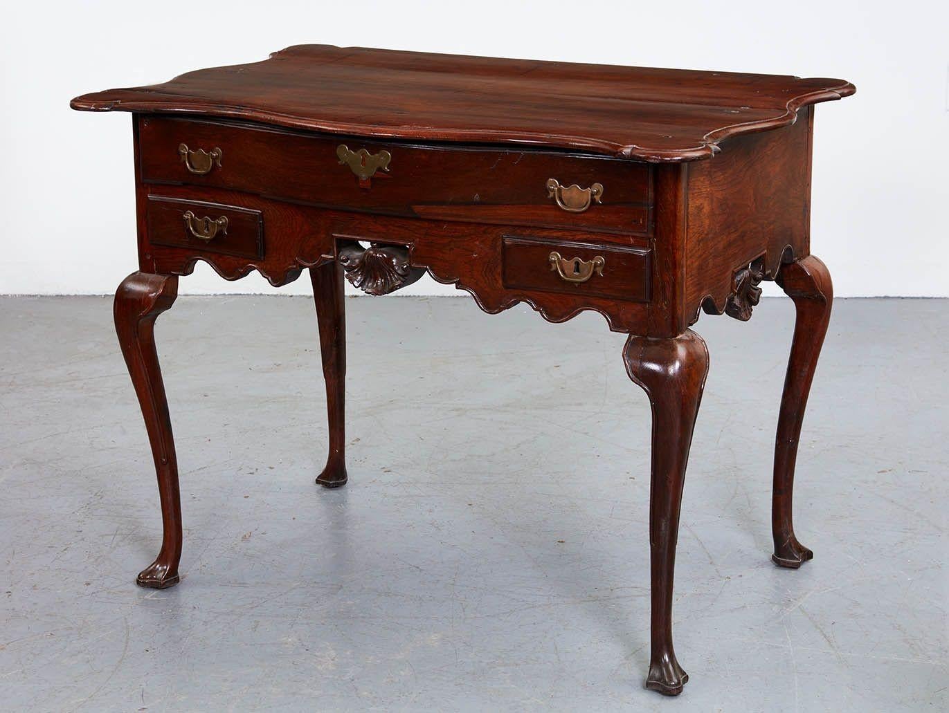 Fine Portuguese rococo side table, all constructed of solid (and extremely heavy!) rosewood, the shaped and thumb molded top over one long and two short drawers, the later flanking a pierced carved shell/fan with molded scalloped apron, the sides