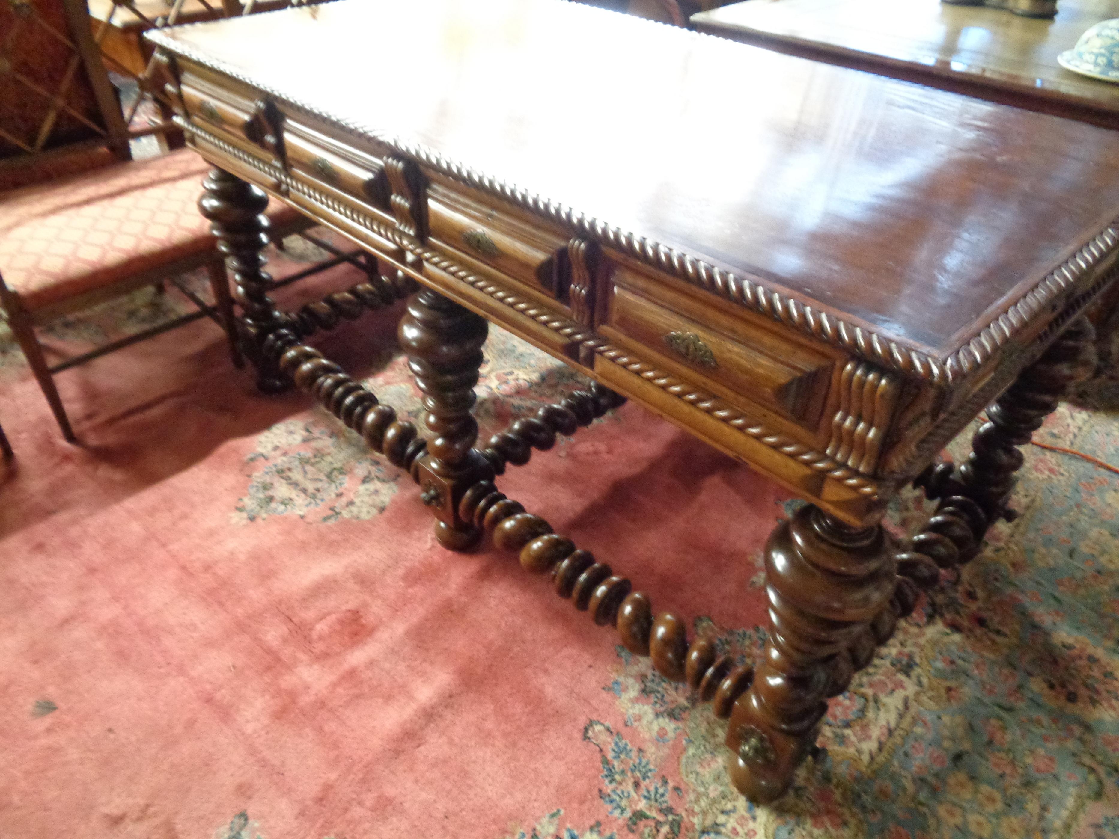 Very fine Portuguese rosewood double sided center/console table with stylized carving throughout. It has drawers on both sides and is supported by graduated bulbous turned legs. There are barley twist supports between the legs. The perimeter of the