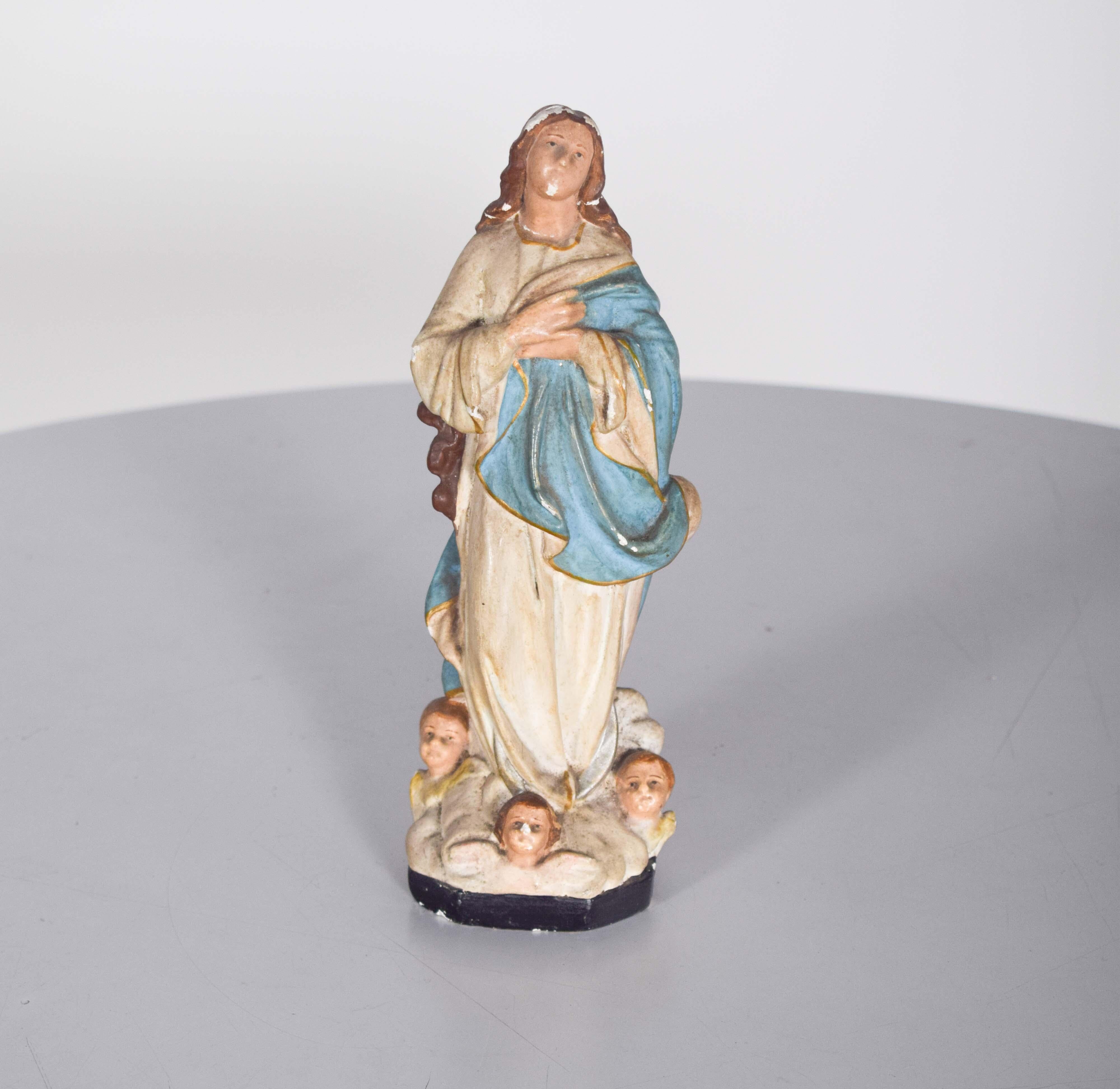 Questa scultura portoghese di Nossa Senhora da Imaculada Conceição è un'affascinante opera religiosa, realizzata in gesso con una delicata attenzione ai dettagli. La figura raffigura la Vergine Maria con le mani giunte in preghiera, simbolo di
