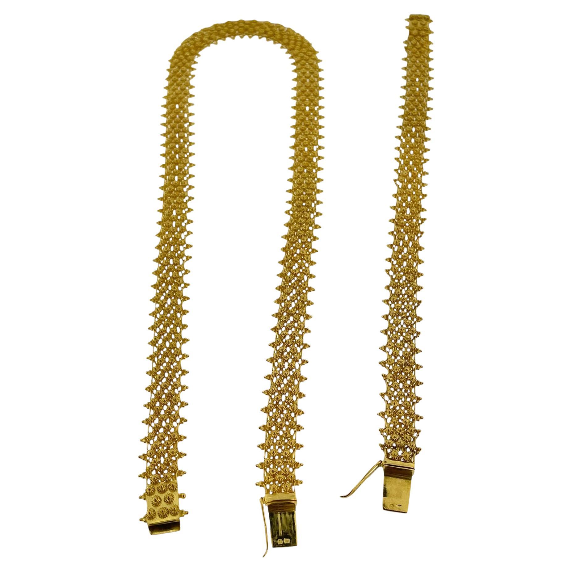 Dieses **Portugiesische Set** besteht aus einem wunderschönen handgefertigten **Armband und einer Halskette**, beide aus exquisitem 19-karätigem Gelbgold, das die reiche Tradition der portugiesischen Schmuckherstellung widerspiegelt. Das Set ist mit