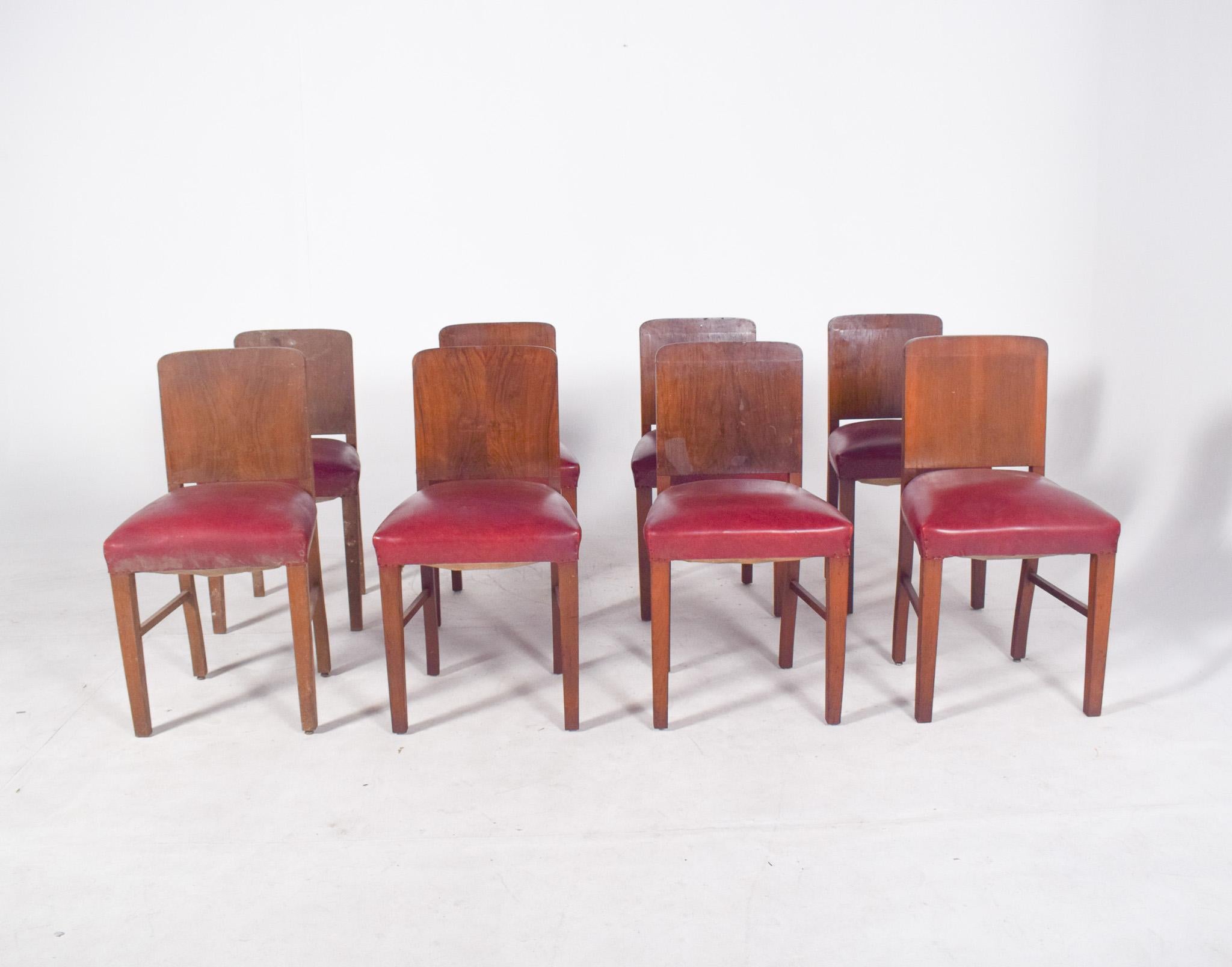 Set di otto sedie da pranzo in stile Deco. Con linee sobrie e una robusta struttura in legno, hanno un design funzionale e di ispirazione moderna, evidenziato da uno schienale leggermente curvo in legno massiccio e da una seduta rivestita in nappa