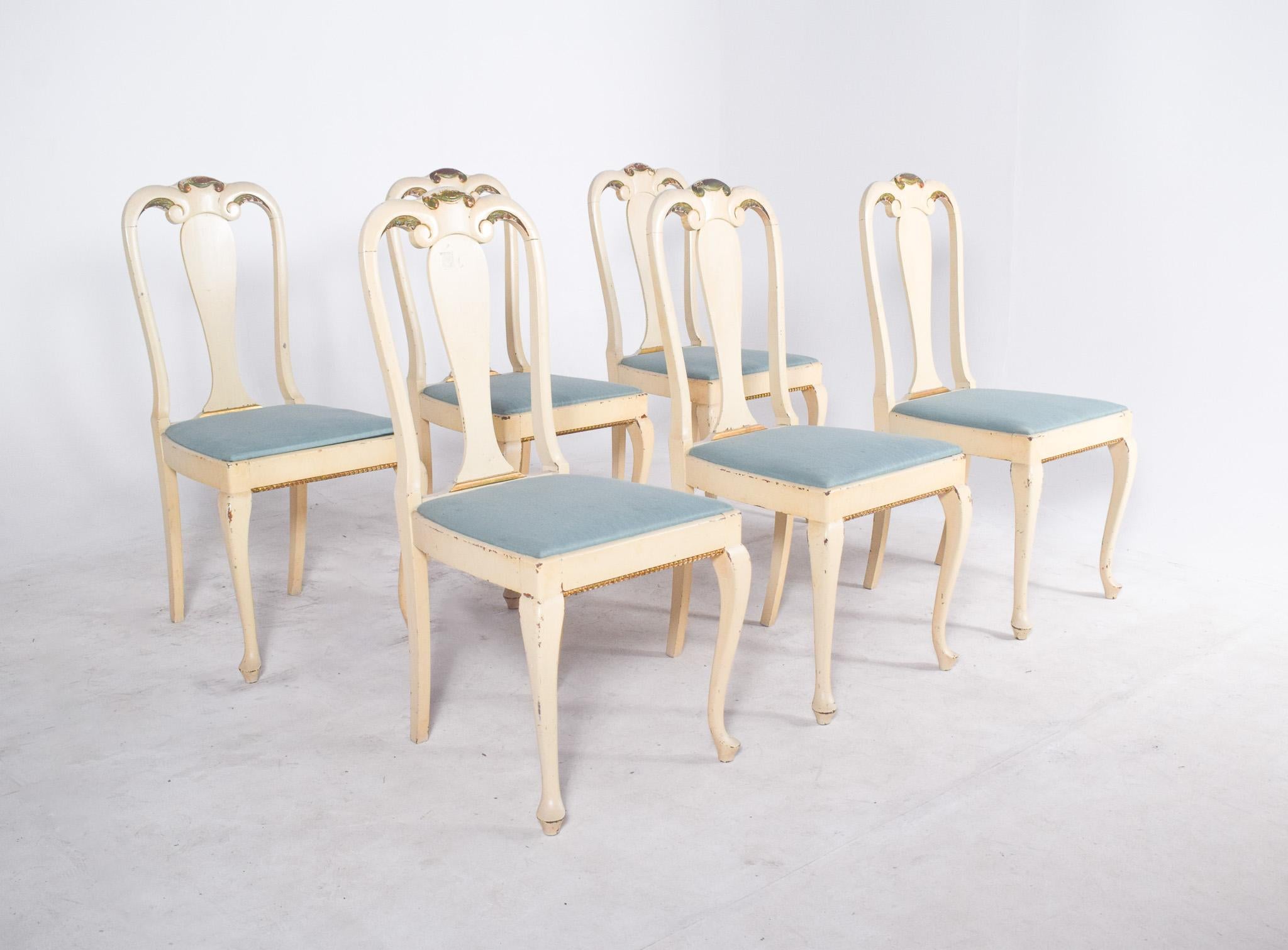 Sechs weiß gestrichene Holzstühle. Dieses Set aus sechs Stühlen zeigt einen klassischen, romantischen Stil, der vom französischen Design beeinflusst ist. Die weiß gestrichenen Holzrahmen mit einem Hauch von Grün auf der Rückseite und einer leichten