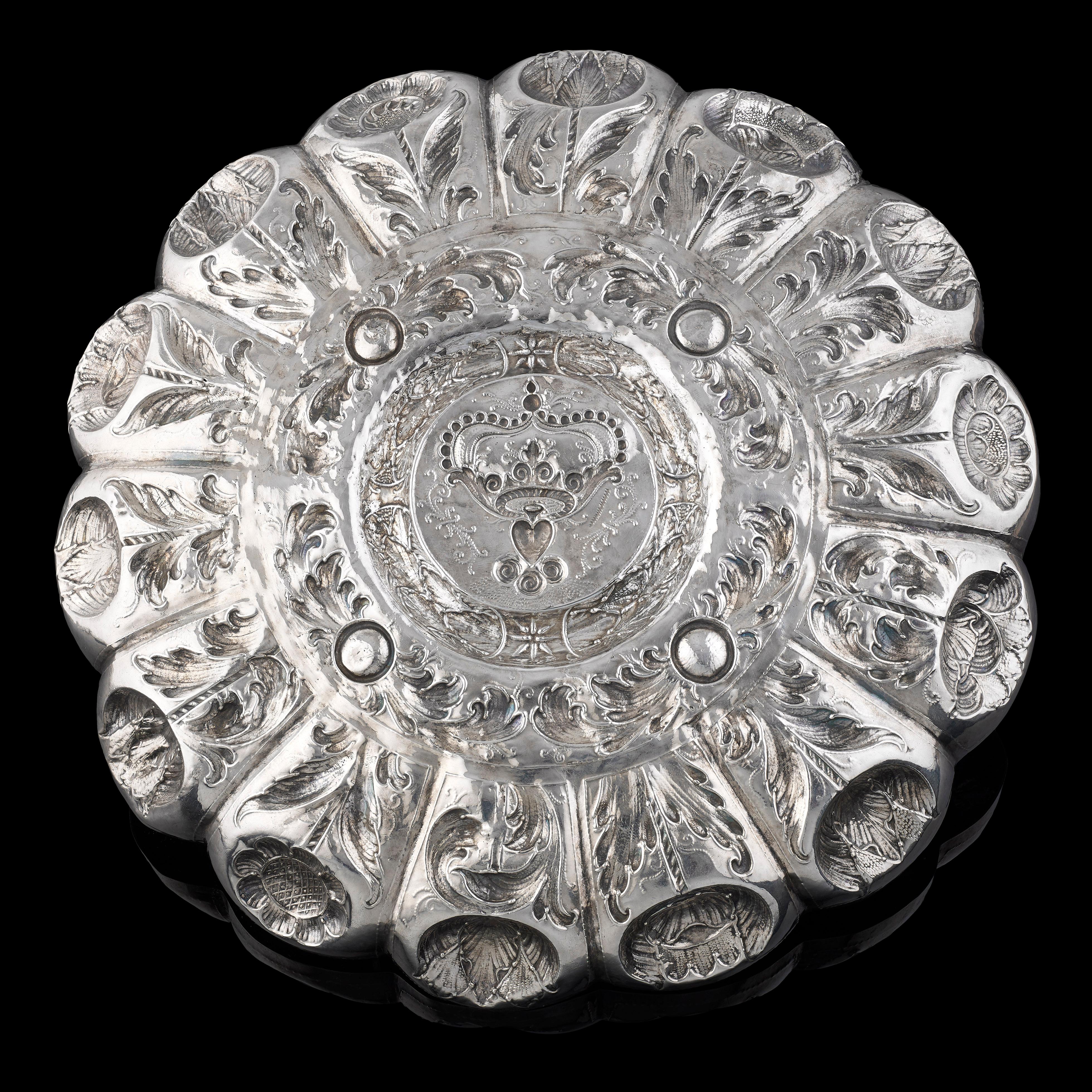 A Portuguese silver salver, circa 1700, heavily chased with stylized flowers, the central reserve with a crown; Lisbon mark and maker's mark PDC - see p.160, no. L-461 Marcas de Pratas Portuguesas e Brasileiras by Fernando Moitinho de Almeida.